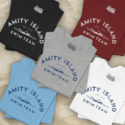 Group of 5 folded Soft unisex Bella+Canvas 3001 short-sleeve t-shirts featuring an Amity Island Swim Team logo graphic, designed by ScriptedBrand, and  inspired by the movie Jaws in a vintage distressed style.