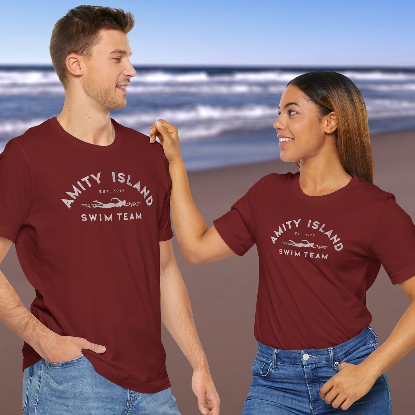 3 models wearing cardinal red lifeguard colored Soft unisex Bella+Canvas 3001 short-sleeve t-shirts featuring an Amity Island Swim Team logo graphic, designed by ScriptedBrand, and  inspired by the movie Jaws in a vintage distressed style.
