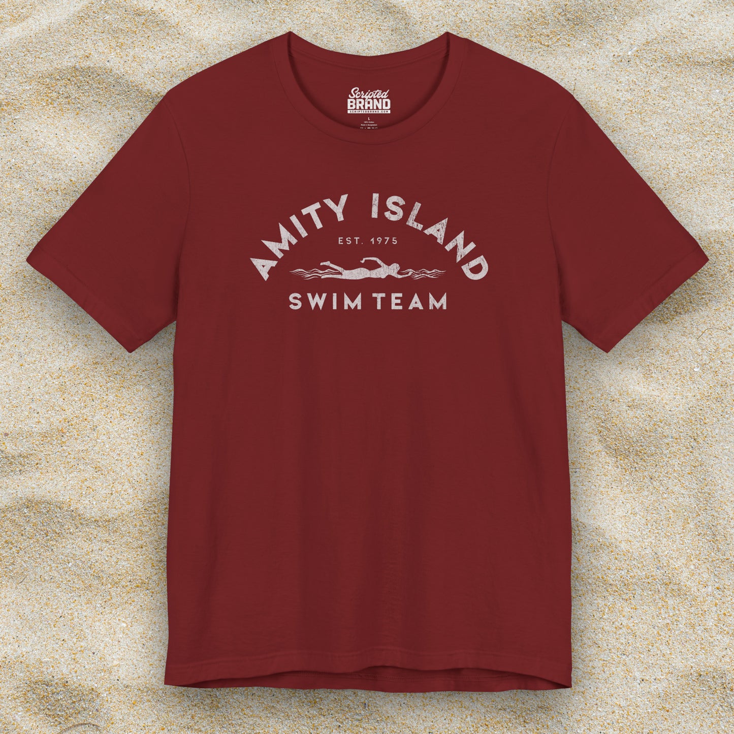 Front view of a cardinal red lifeguard colored Soft unisex Bella+Canvas 3001 short-sleeve t-shirt featuring an Amity Island Swim Team logo graphic, designed by ScriptedBrand, and  inspired by the movie Jaws in a vintage distressed style.