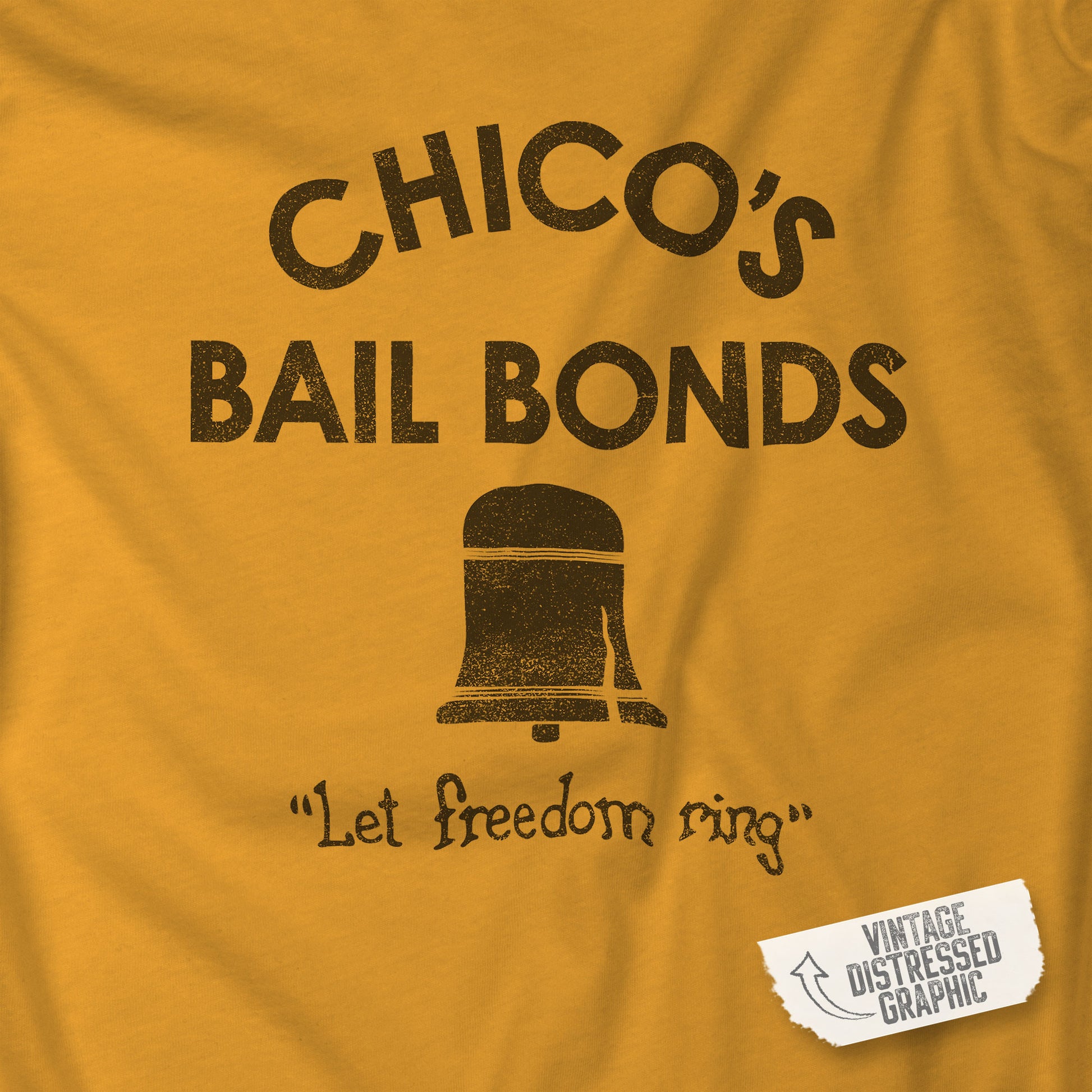 Closeup of gold t-shirt with distressed Chico’s Bail Bonds logo and “Let freedom ring” slogan from The Bad News Bears movie.
