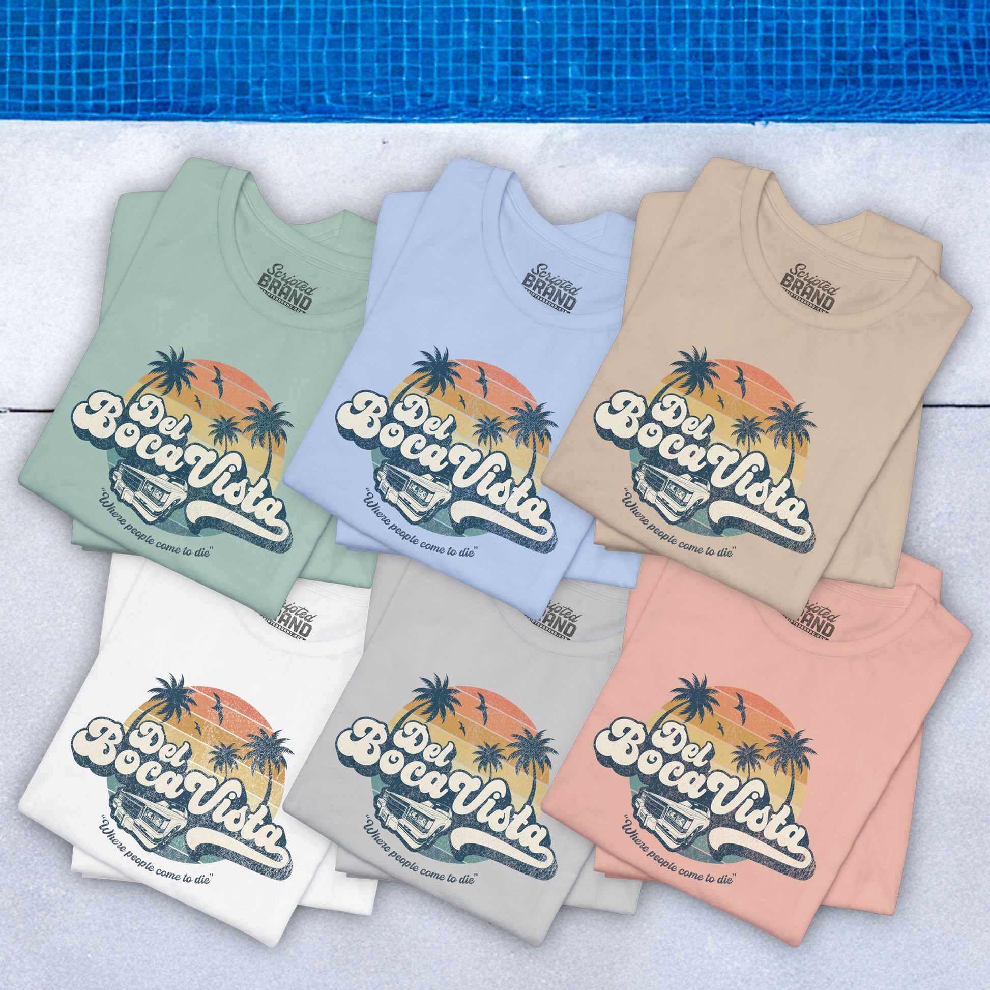 Six folded Bella+Canvas 3001 t-shirts featuring a Del Boca Vista graphic with the phrase Where People Come To Die, inspired by Seinfeld, in a vintage distressed style, laid out near a pool.