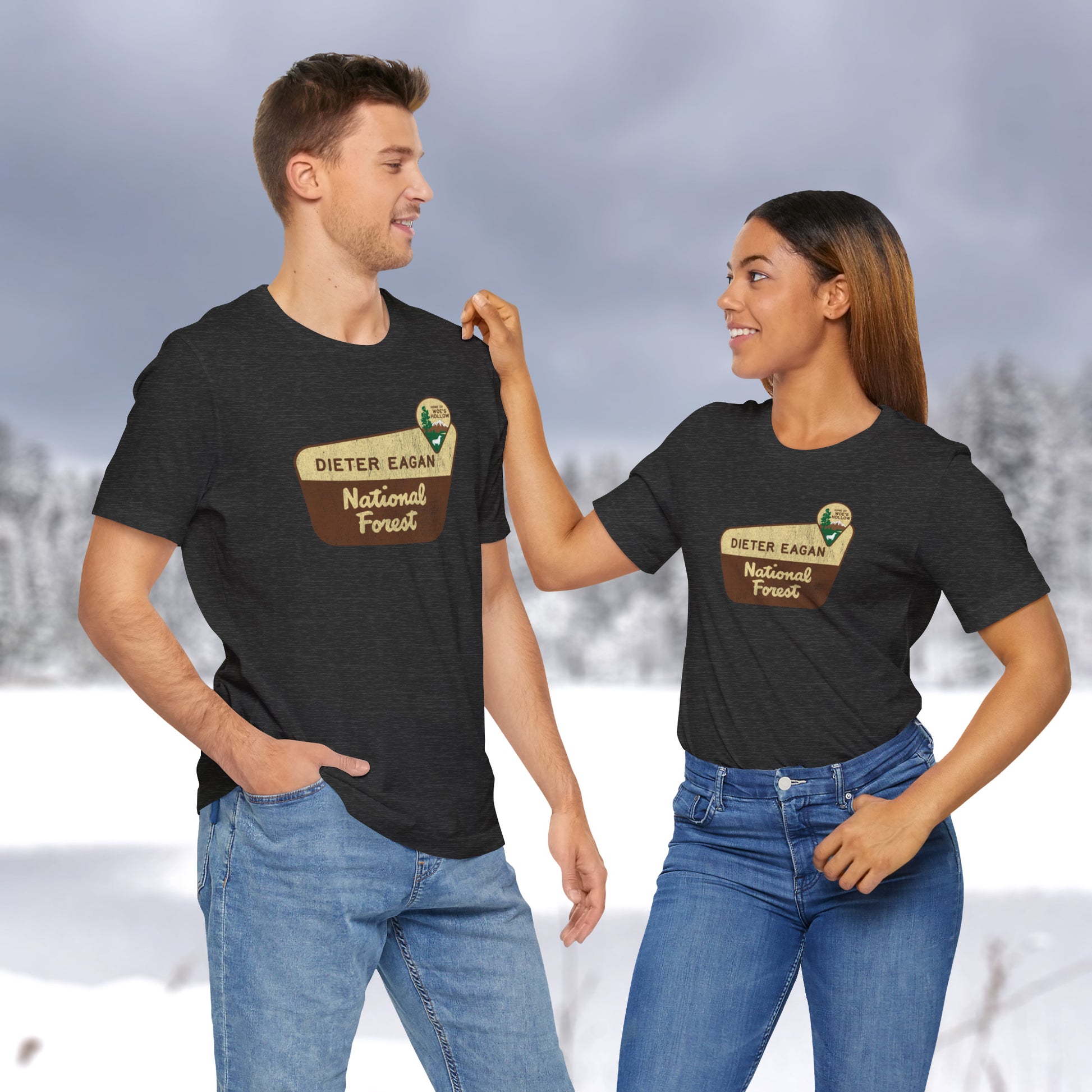 2 models wearing soft Bella+Canvas short-sleeve t-shirts with the logo graphic of the Dieter Eagan National Forest inspired by the TV show Severance in a vintage distressed ink-stamped worn-in style.