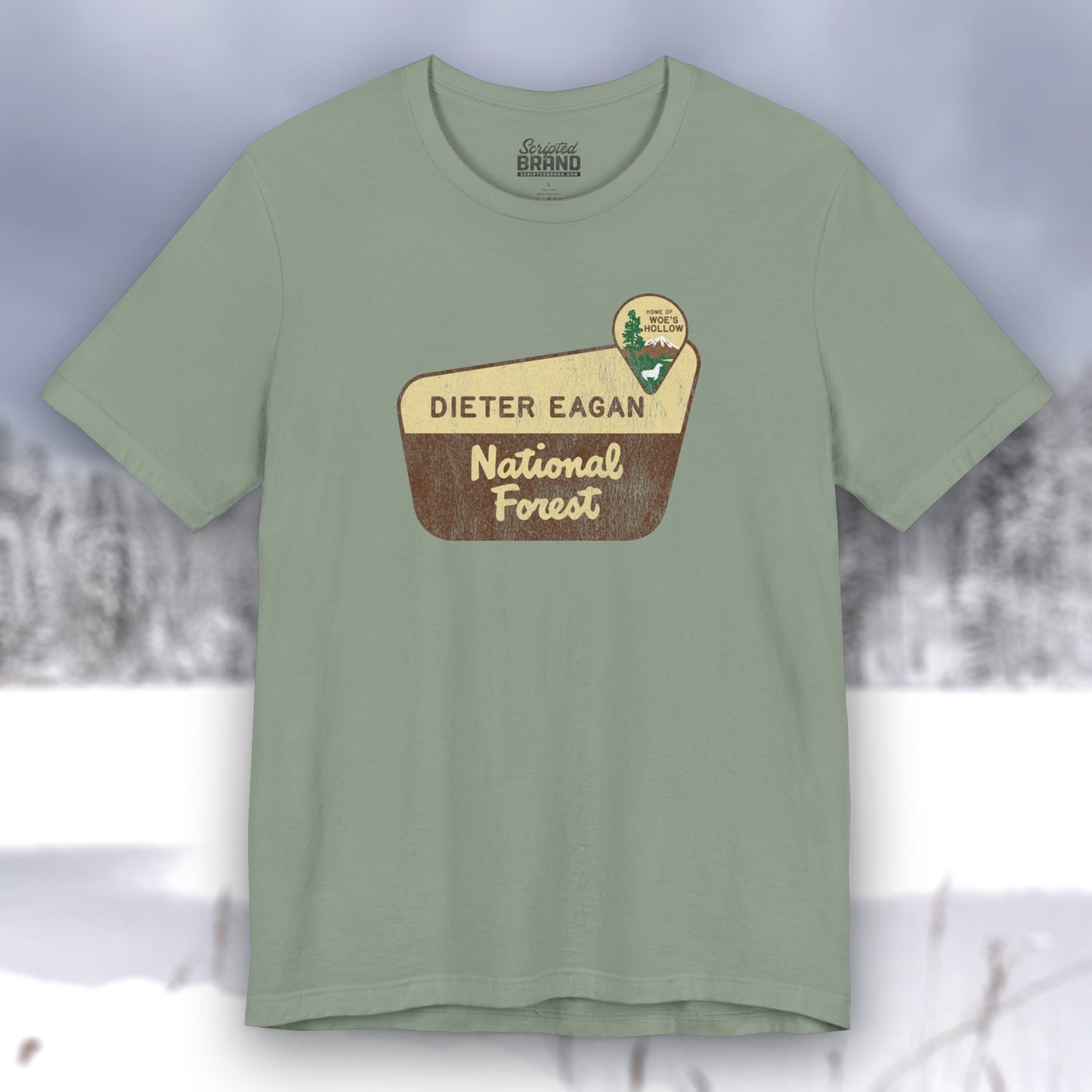 Sage green colored soft Bella+Canvas short-sleeve t-shirt with the logo graphic of the Dieter Eagan National Forest inspired by the TV show Severance in a vintage distressed ink-stamped worn-in style.