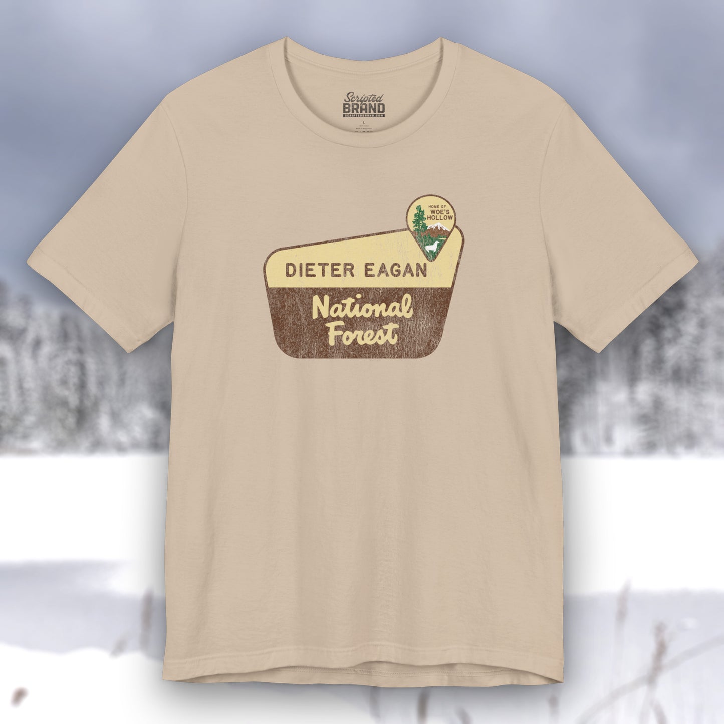 Tan colored soft Bella+Canvas short-sleeve t-shirt with the logo graphic of the Dieter Eagan National Forest inspired by the TV show Severance in a vintage distressed ink-stamped worn-in style.