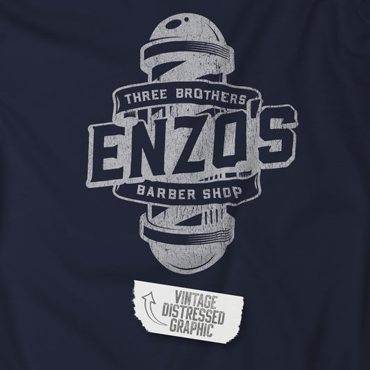 Closeup of a navy t-shirt with the Enzo's Barber Shop logo graphic inspired by the TV show Seinfeld in a vintage distressed style.
