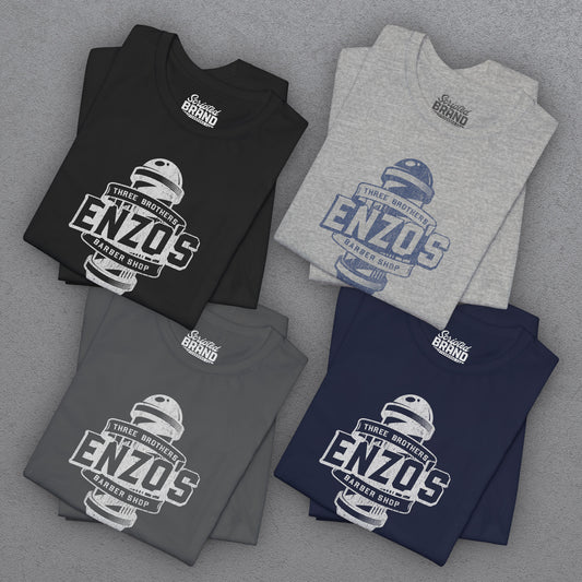 Four folded t-shirts with Enzo's Barber Shop logo graphic inspired by the TV show Seinfeld in a vintage distressed style.