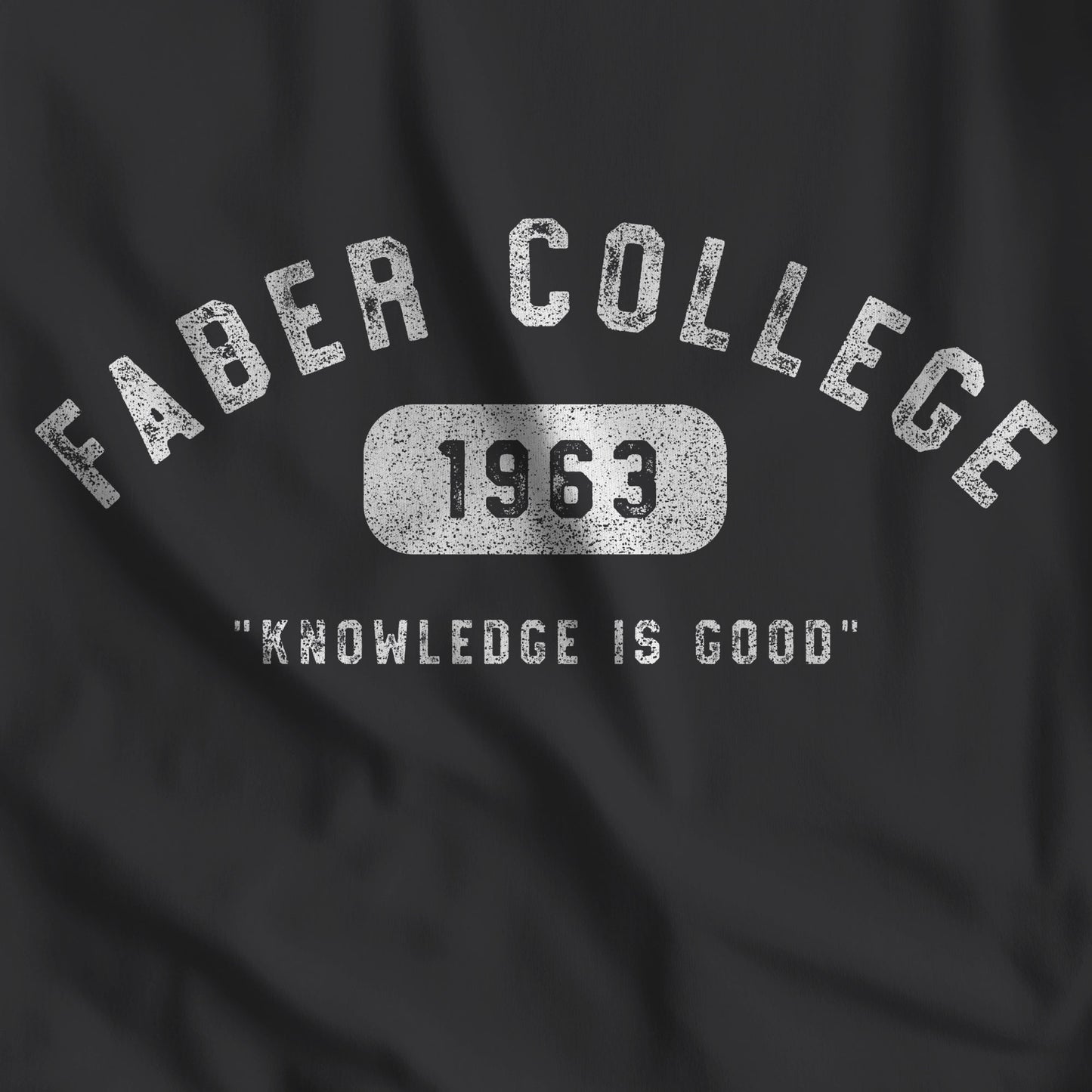 Closeup of black t-shirt with the Faber College logo and Knowledge Is Good from the movie Animal House in a vintage distressed style.