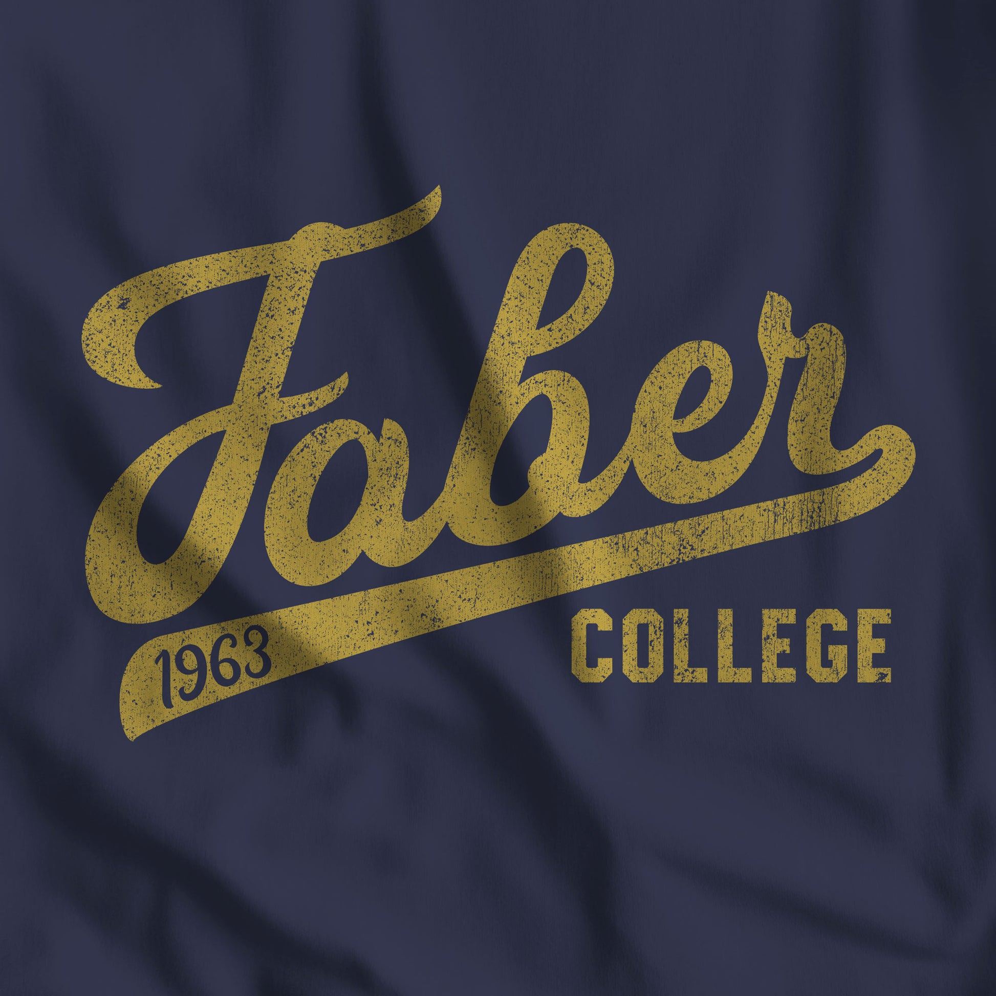 Closeup of a Bella+Canvas t-shirt with the Faber College Script logo from the movie Animal House in a vintage distressed style.