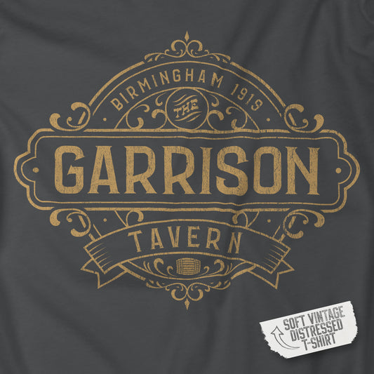 Closeup view of a asphalt gray soft Bella+Canvas 3001 short-sleeve t-shirt featuring the Garrison Tavern Bar Logo Graphic inspired by the TV show and movie Peaky Blinders in a vintage distressed style, sold by ScriptedBrand.