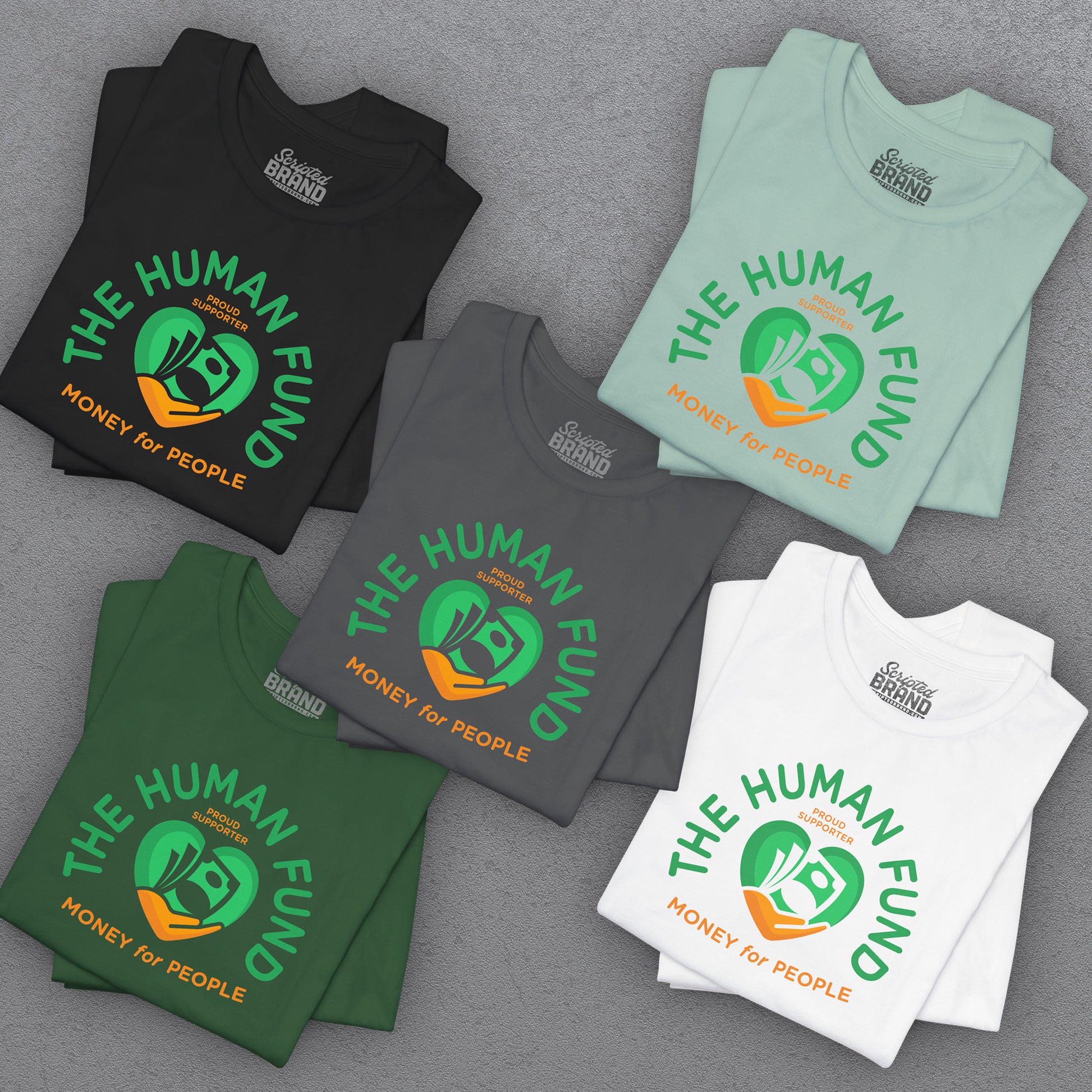 Stacks of t-shirts with 'The Human Fund' logo on a gray surface