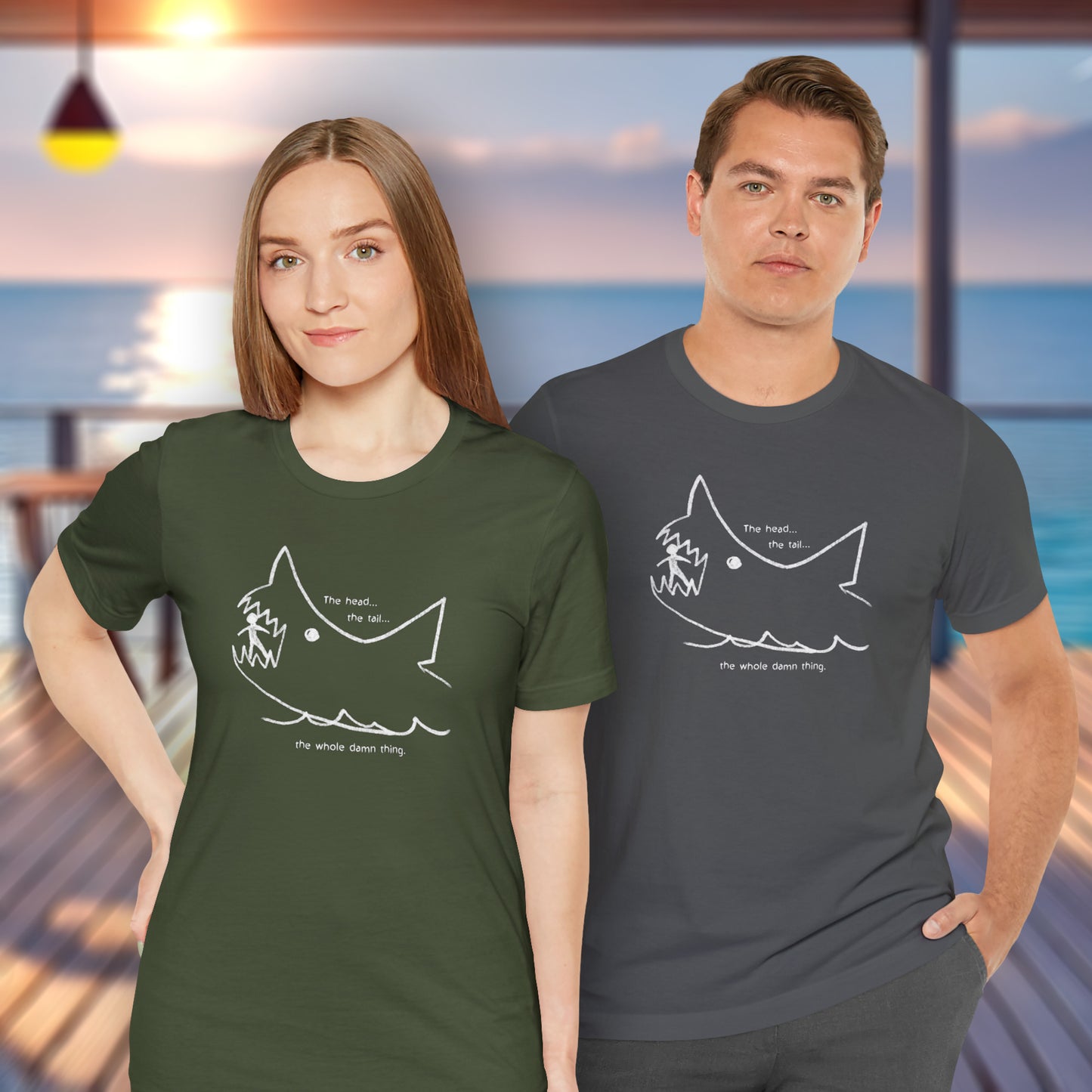 2 models wearing military green and  asphalt gray colored soft short-sleeve Bella+Canvas 3001 t-shirts featuring the chalkboard drawing of a shark eating a person, drawn by Quint in the movie Jaws.