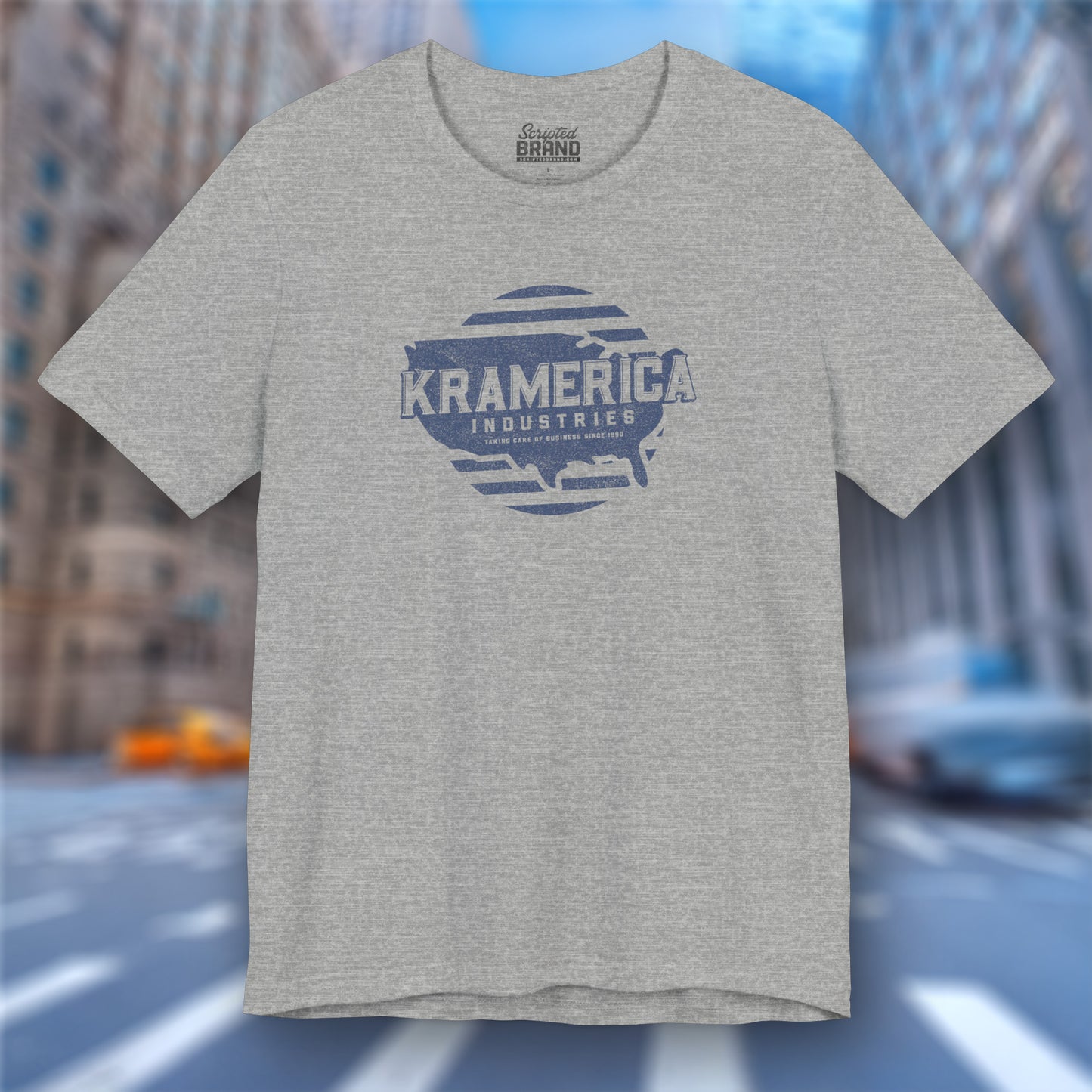 Heather gray t-shirt featuring a Kramerica logo graphic inspired by the TV show Seinfeld in a vintage distressed style.