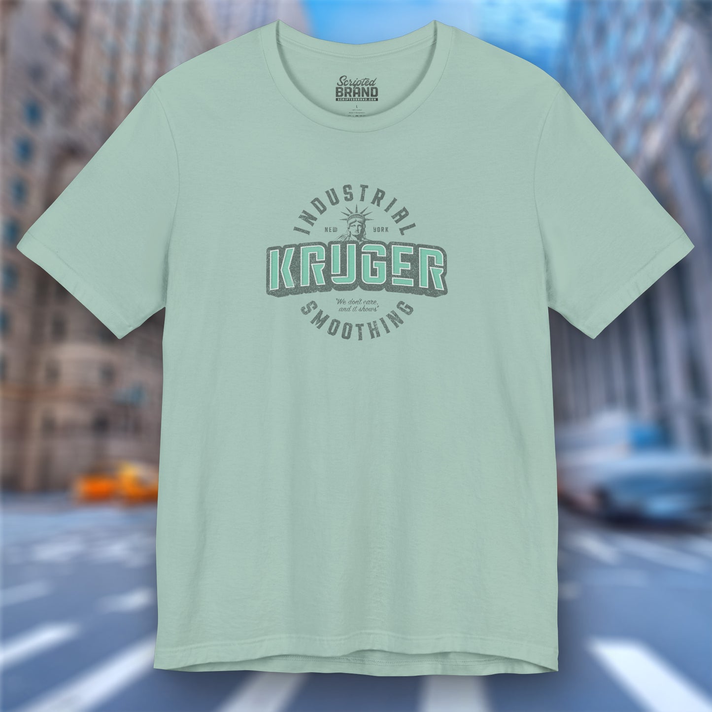 Front view of a dusty blue colored Soft unisex Bella+Canvas 3001 short-sleeve t-shirt featuring a Kruger Industrial Smoothing logo graphic in a vintage distressed style, designed by ScriptedBrand, and  inspired by the TV show Seinfeld.