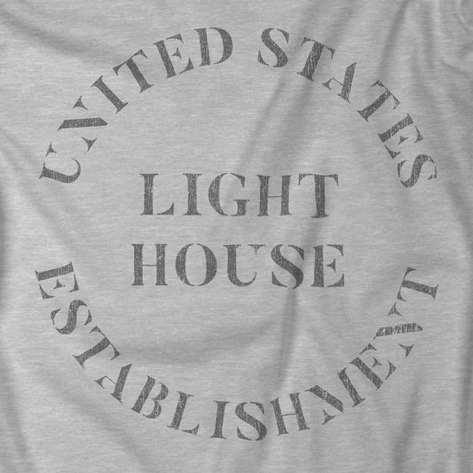 Closeup of Gray t-shirt featuring the United States Light House Establishment logo graphic worn by Robert Pattinson in the movie The Lighthouse in a vintage distressed style.