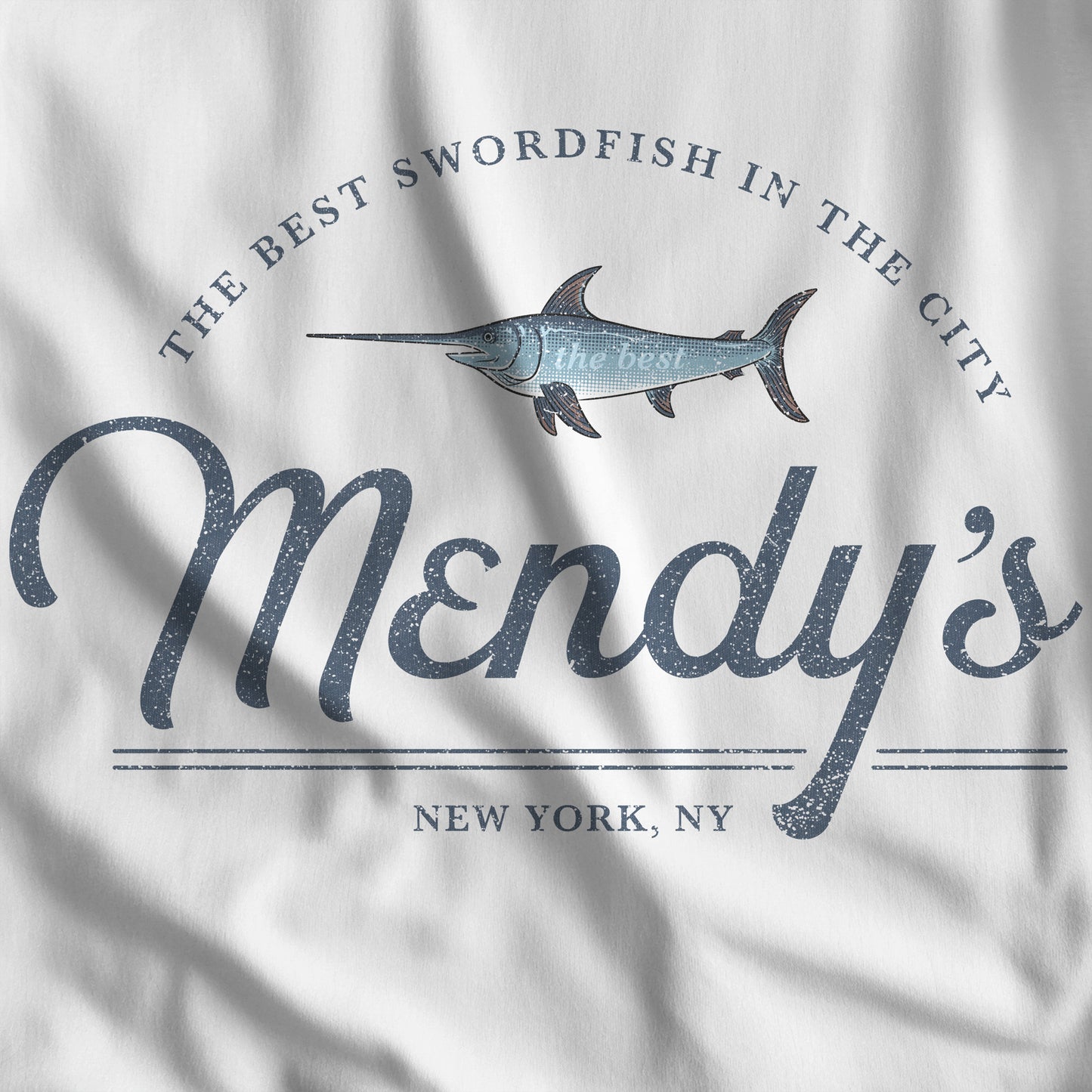 Closeup of white t-shirt featuring a Mendy's Restaurant logo graphic inspired by the TV show Seinfeld in a vintage style.