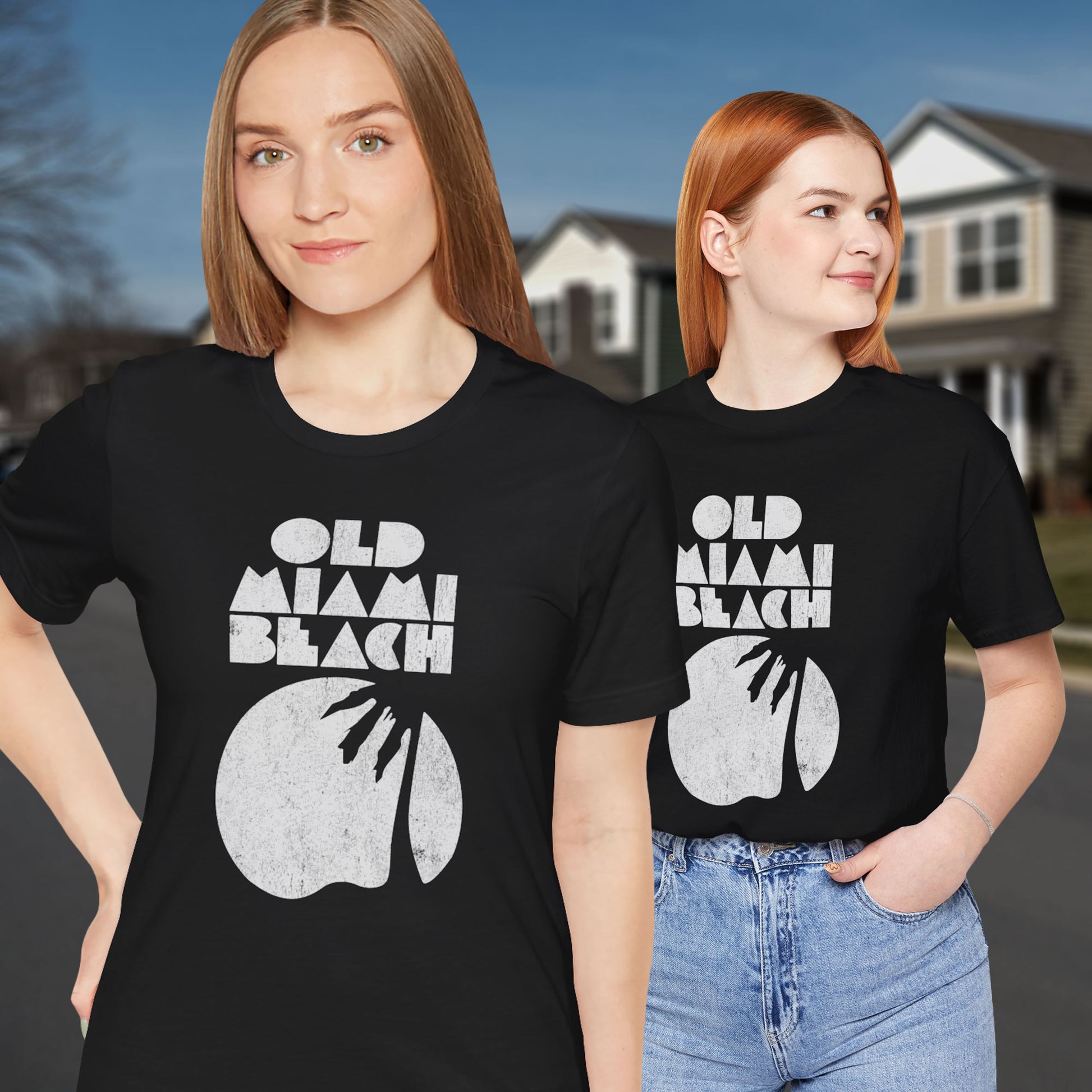 two women wearing Black Bella+Canvas 3001 T-shirts with distressed “Old Miami Beach” graphic, inspired by Julia Garner’s shirt in Weapons movie.