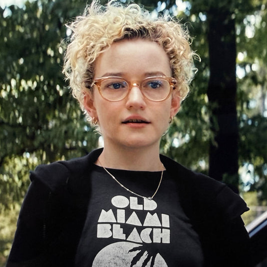 Julia Garner wearing a black T-shirt with distressed “Old Miami Beach” graphic in the movie Weapons.