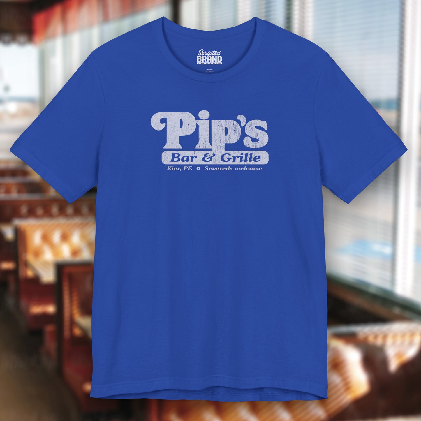 Royal Blue colored soft Bella+Canvas shirtsleeve t-shirt with the Pips Bar and Grill logo from the TV show Severance in a vintage distressed ink-stamped worn-in style.