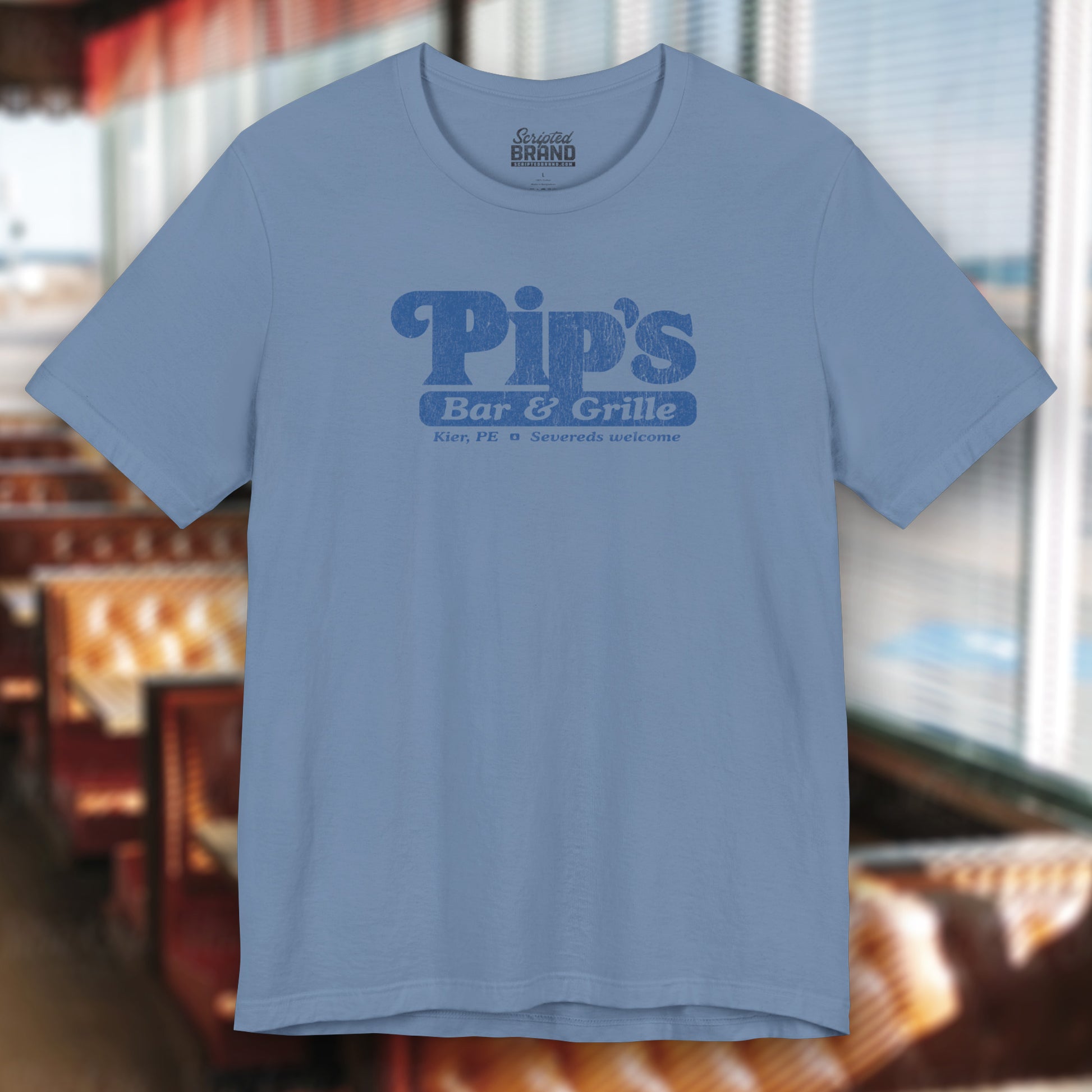 Front of a steel blue colored soft Bella+Canvas shirtsleeve t-shirt with the Pips Bar and Grill logo from the TV show Severance in a vintage distressed ink-stamped worn-in style.