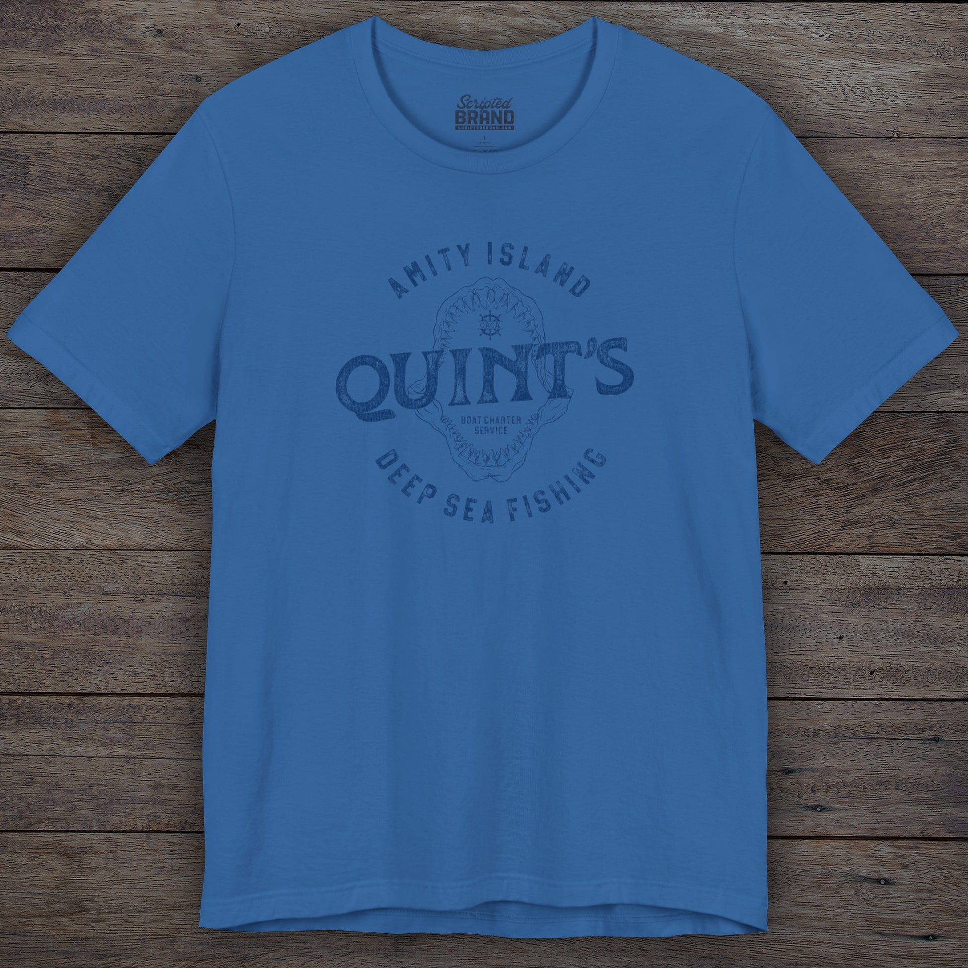 Columbia blue colored Soft short-sleeve t-shirt featuring the Quint's Deep Sea Fishing Boat Charters logo graphic inspired by the movie Jaws in a vintage distressed ink-stamped worn-in style.