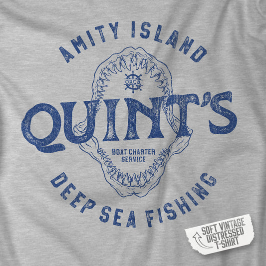 Closeup of a Athletic Heather Gray Soft short-sleeve t-shirt featuring the Quint's Deep Sea Fishing Boat Charters logo graphic inspired by the movie Jaws in a vintage distressed ink-stamped worn-in style.
