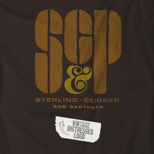 Closeup view of a brown colored soft unisex Bella+Canvas 3001 short-sleeve t-shirt featuring the Sterling Cooper & Partners logo graphic from the TV Show Mad Men in a vintage distressed style, sold by ScriptedBrand.