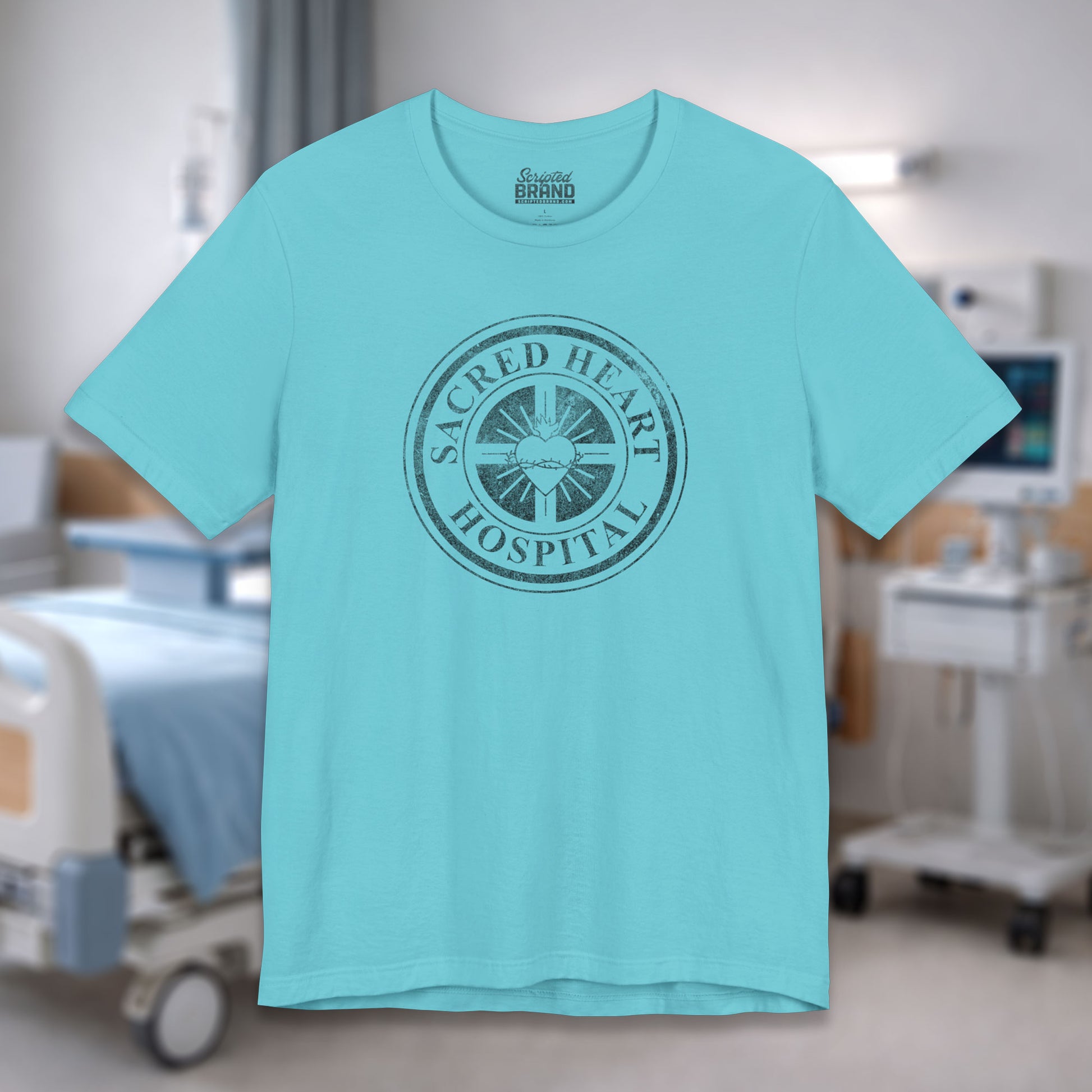 Turquoise blue Bella Canvas 3001 tee with vintage distressed Sacred Heart Hospital logo from Scrubs printed on chest, shown in a hospital.