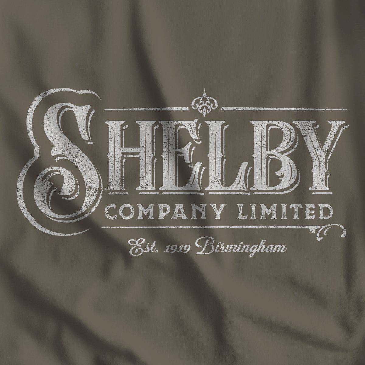 Closeup of army colored Bella+Canvas 3001 t-shirt featuring a vintage Shelby Company Limited logo from Peaky Blinders.