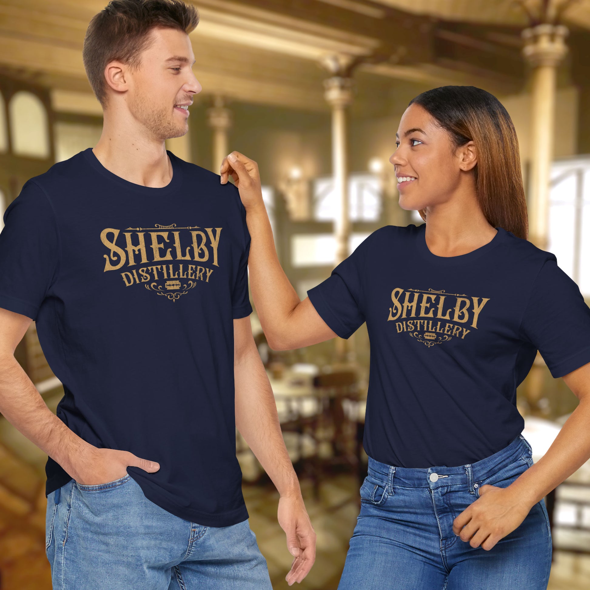 2 models wearing navy blue Soft Bella+Canvas 3001 short-sleeve t-shirts featuring the Shelby Company Limited Distillery Logo Graphic inspired by the TV show and movie Peaky Blinders in a vintage distressed style, sold by ScriptedBrand.