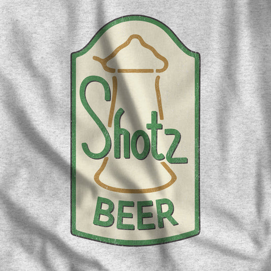 Closeup of Heather gray t-shirt with distressed Shotz Beer Brewery logo graphic, inspired by TV show Laverne & Shirley.