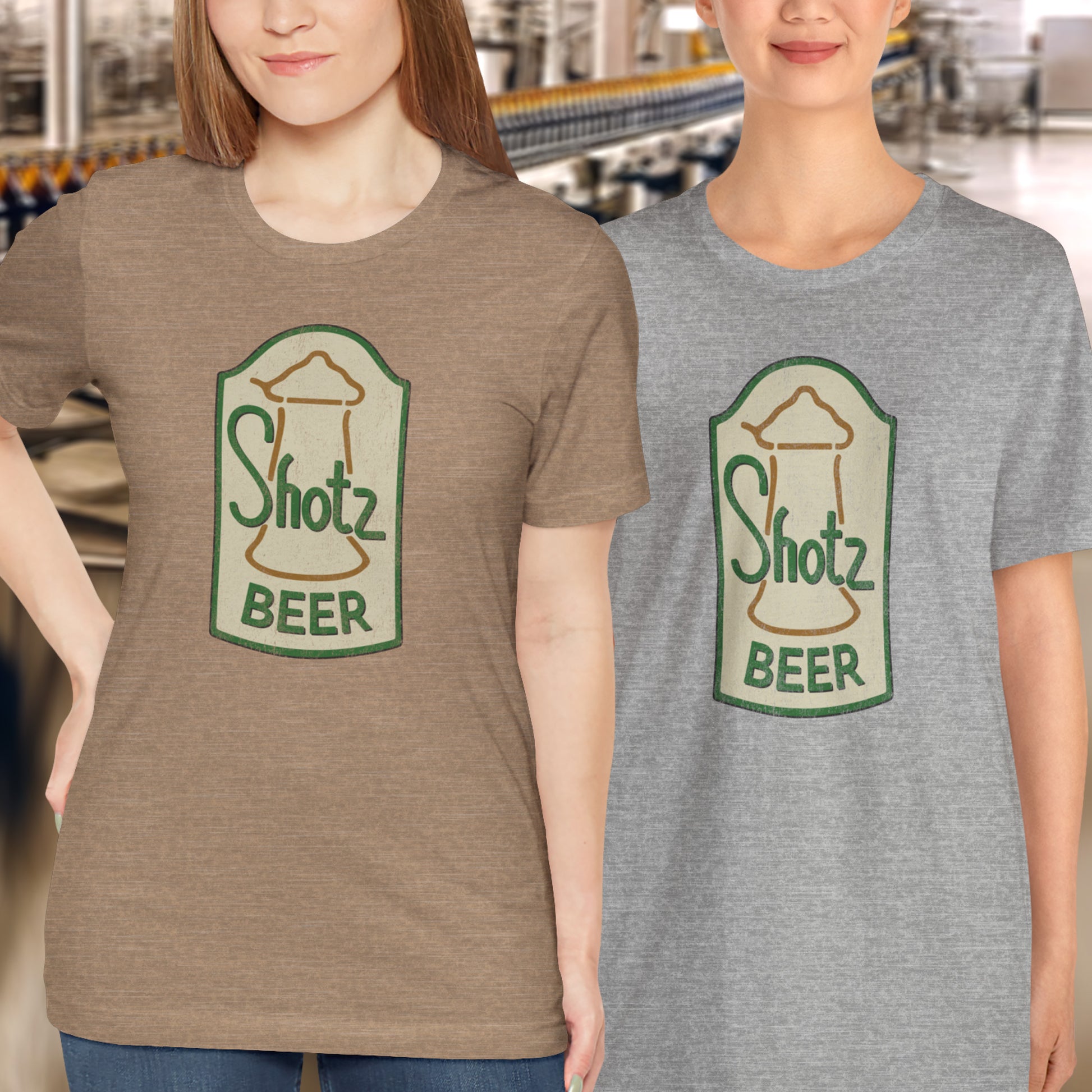 2 female models wearing heather grass green t-shirt with vintage Shotz Beer Brewery logo graphic, inspired by TV show Laverne & Shirley.