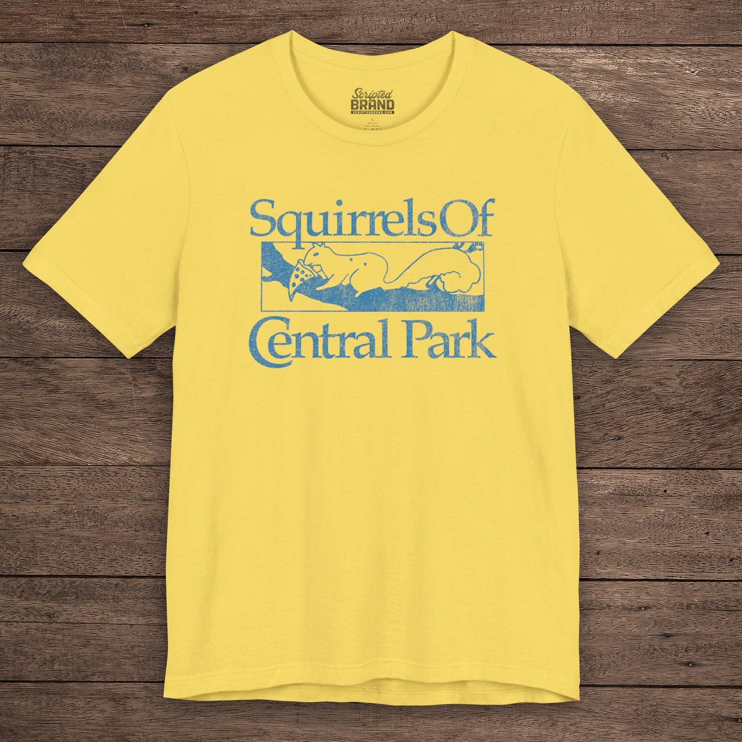 Yellow unisex t-shirt with distressed blue “Squirrels of Central Park” graphic, worn by Eva Garvey in the show Bad Sisters.