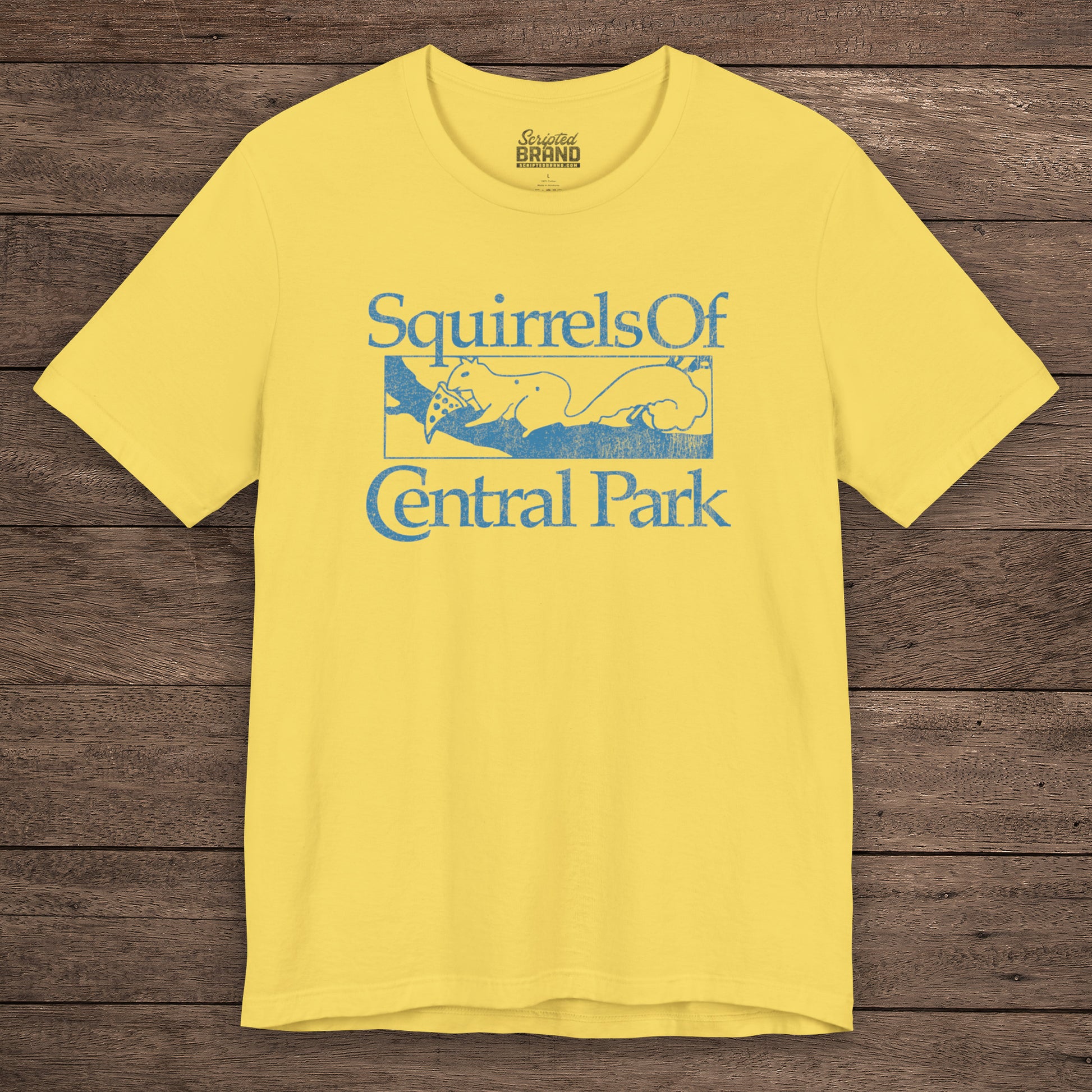 Yellow unisex t-shirt with distressed blue “Squirrels of Central Park” graphic, worn by Eva Garvey in the show Bad Sisters.