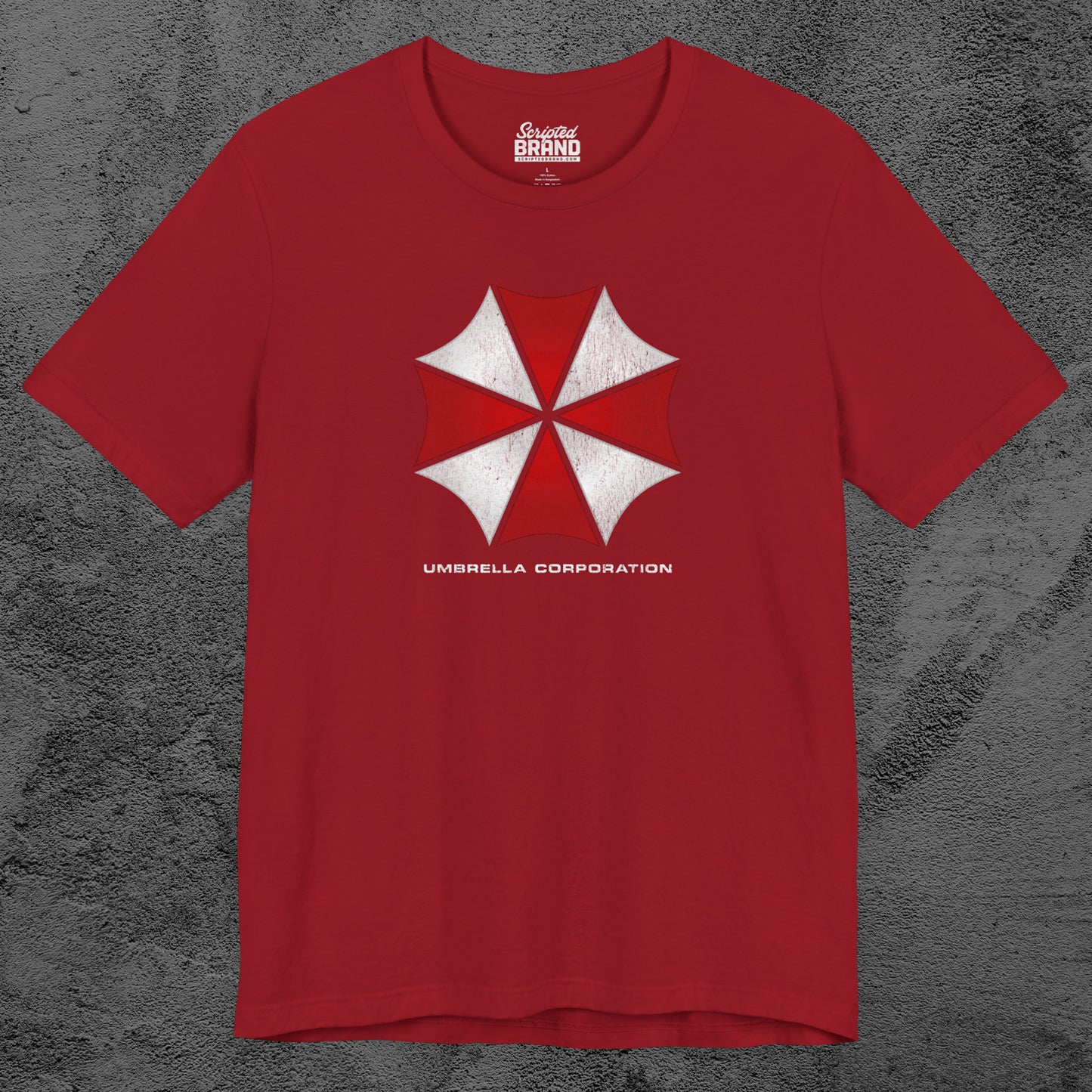 Red t-shirt featuring the Umbrella Corp logo from the video game and movie franchise Resident Evil in a vintage distressed style.