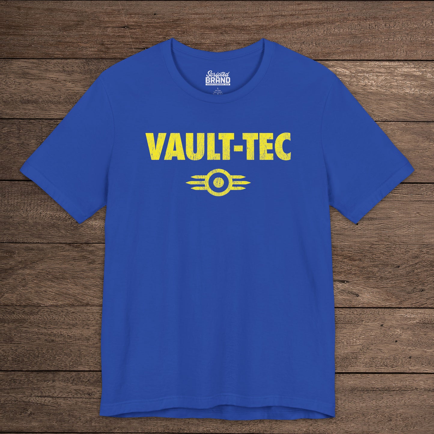 Royal blue t-shirt featuring the Vault-Tec logo graphic from the video game Fallout in a vintage distressed style. 