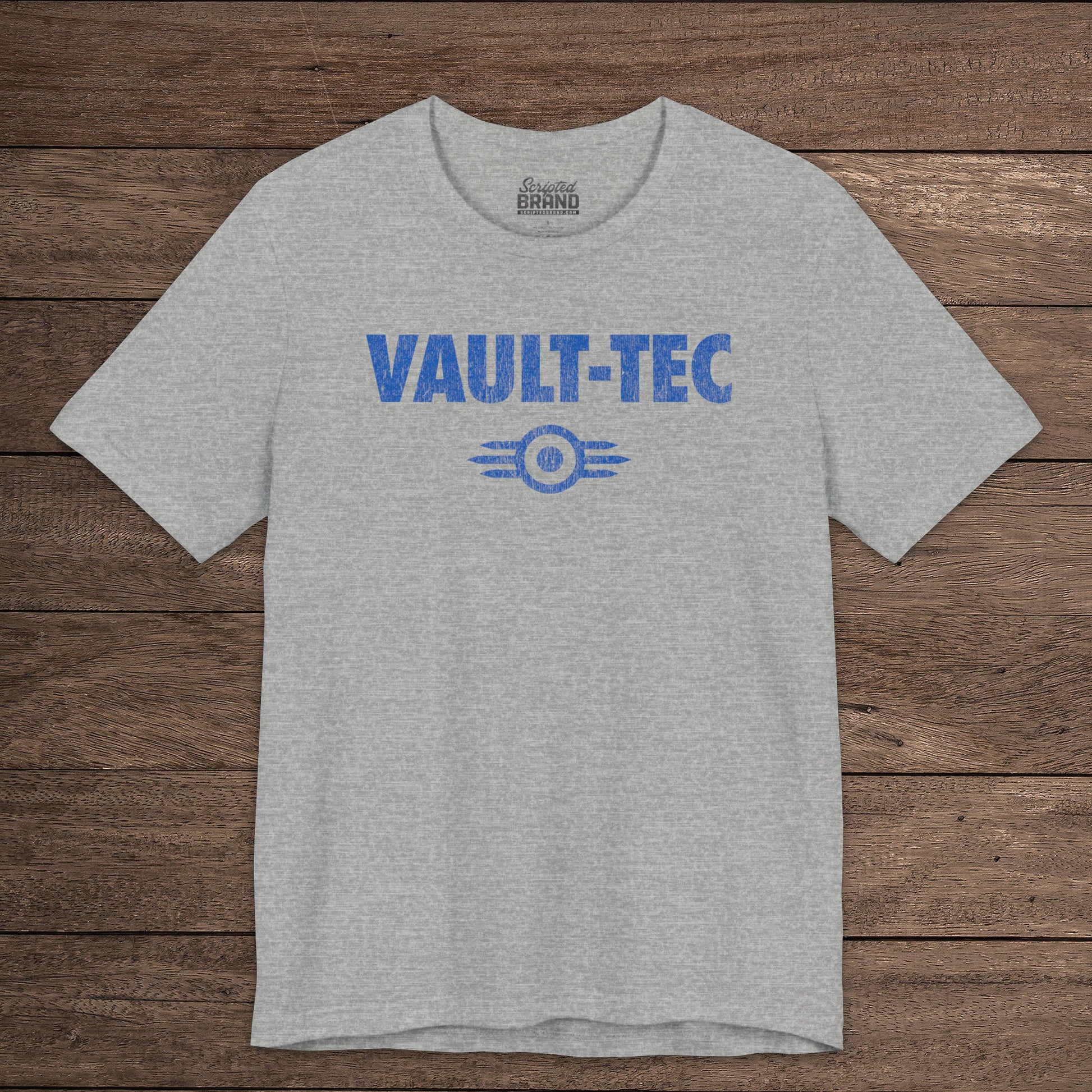 Heather gray t-shirt featuring the Vault-Tec logo graphic from the video game Fallout in a vintage distressed style. 