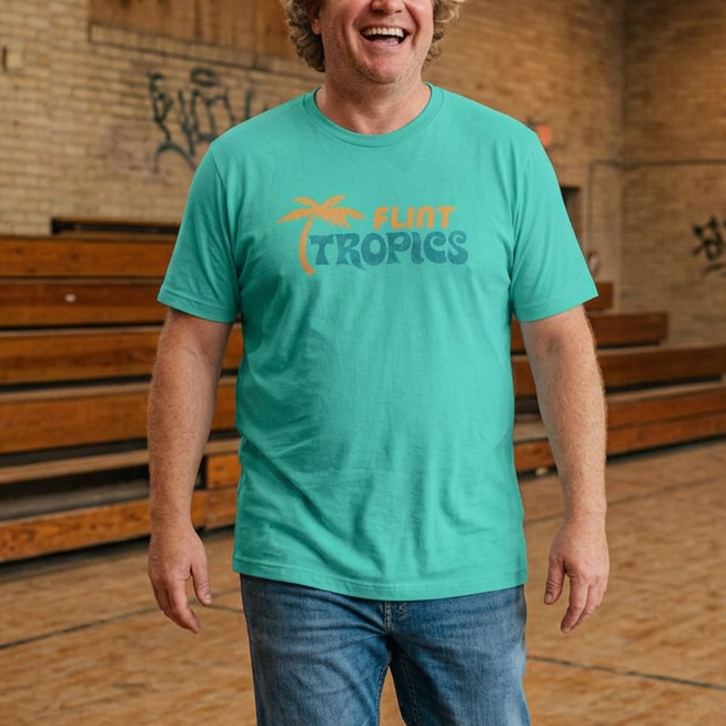 Man wearing teal Bella+Canvas t-shirt with the Flint Tropics logo from the movie Semi-Pro in a vintage distressed style.