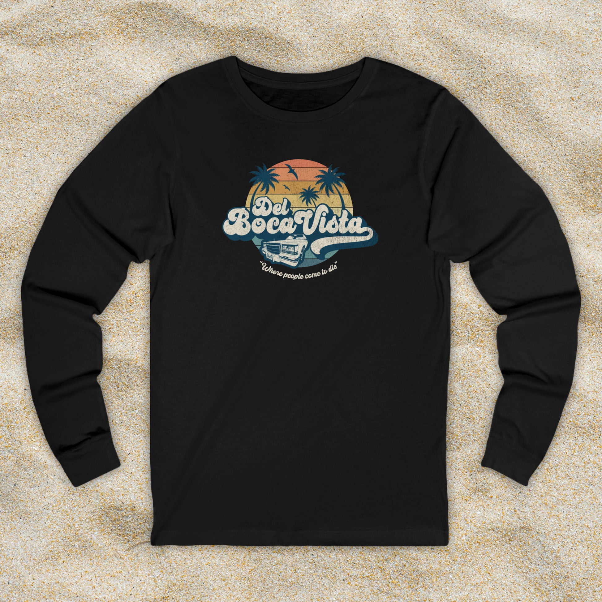 Front view of a black Soft Bella+Canvas 3501 long-sleeve t-shirt featuring a Del Boca Vista logo graphic (uniquely designed by ScriptedBrand), including the phrase Where People Come To Die, inspired by the TV show Seinfeld, in a vintage distressed style.