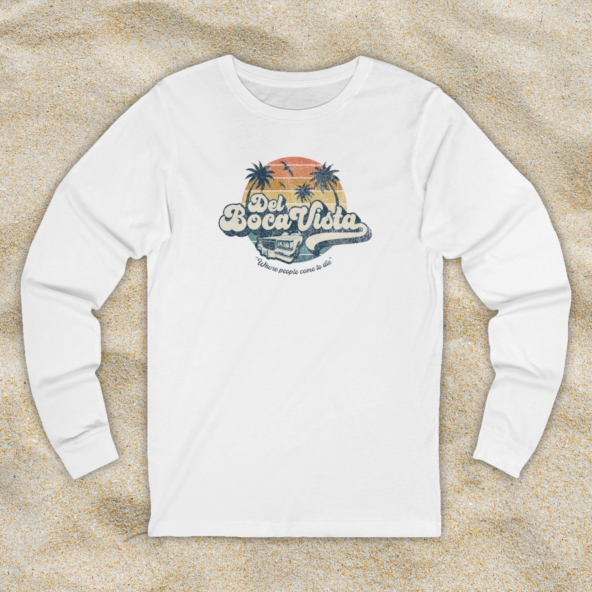 Front view of a white Soft Bella+Canvas 3501 long-sleeve t-shirt featuring a Del Boca Vista logo graphic (uniquely designed by ScriptedBrand), including the phrase Where People Come To Die, inspired by the TV show Seinfeld, in a vintage distressed style.
