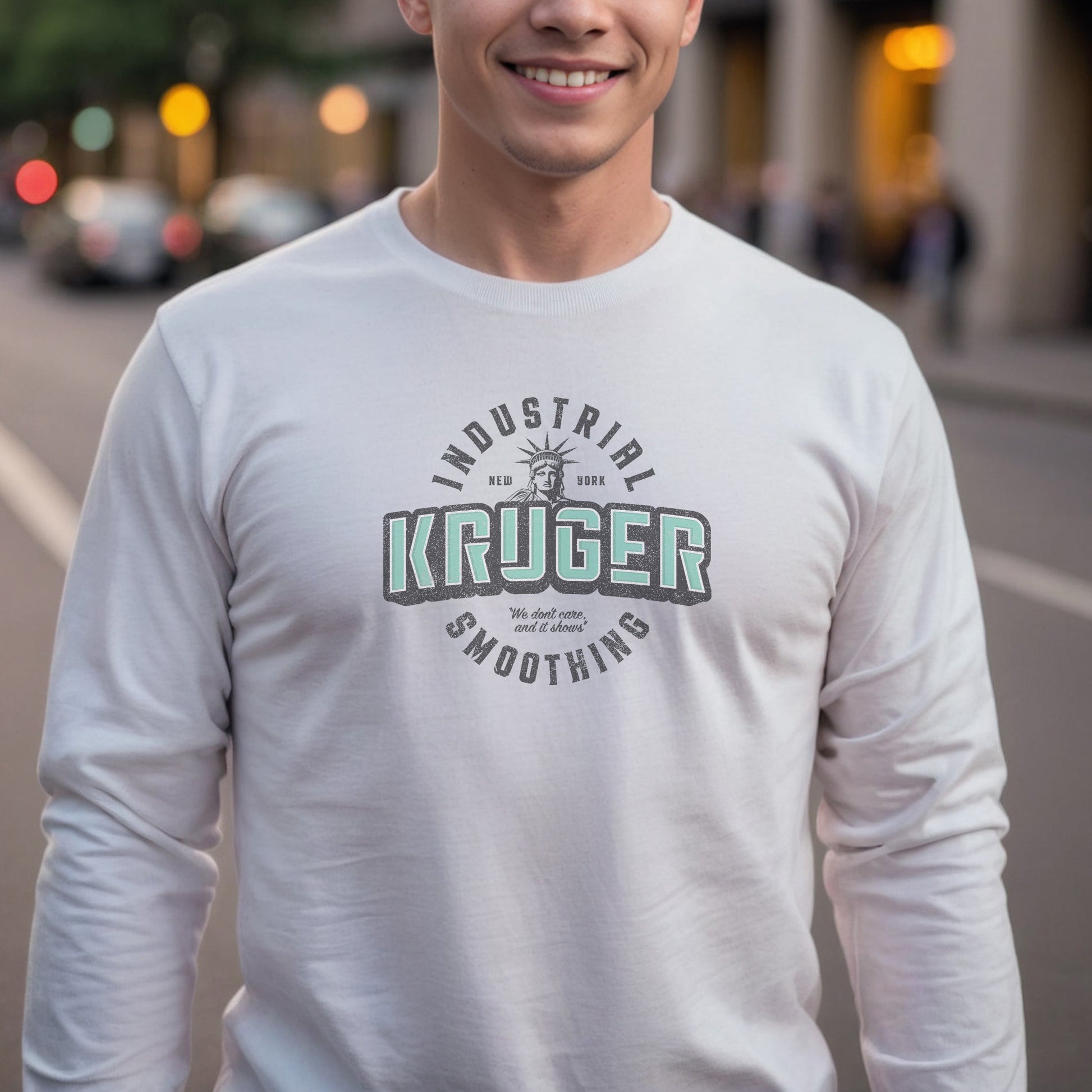 Male model wearing a white colored soft unisex Bella+Canvas 3501 long-sleeve t-shirt featuring a Kruger Industrial Smoothing logo graphic, designed by ScriptedBrand in a vintage distressed style, and  inspired by the TV show Seinfeld. Includes the Statue of Liberty and the the slogan "We don't care and it shows".