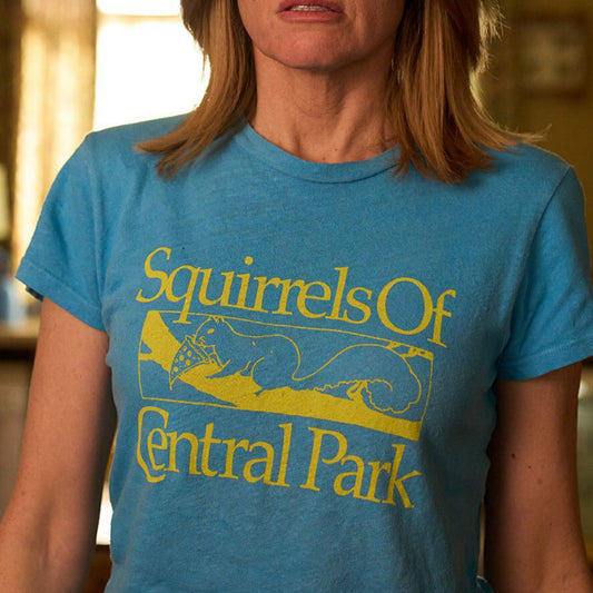 Eva Garvey of Bad Sisters wearing a Turquoise women’s t-shirt with distressed yellow “Squirrels of Central Park” logo