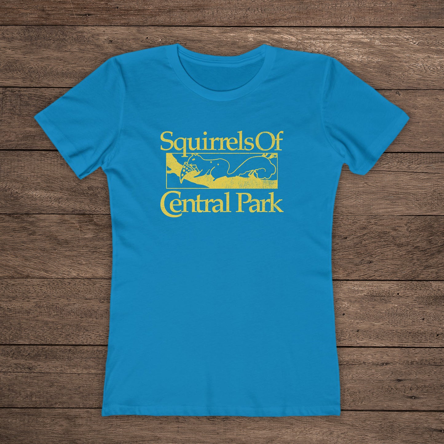 Front view of Turquoise women’s t-shirt with distressed yellow “Squirrels of Central Park” logo inspired by Bad Sisters.