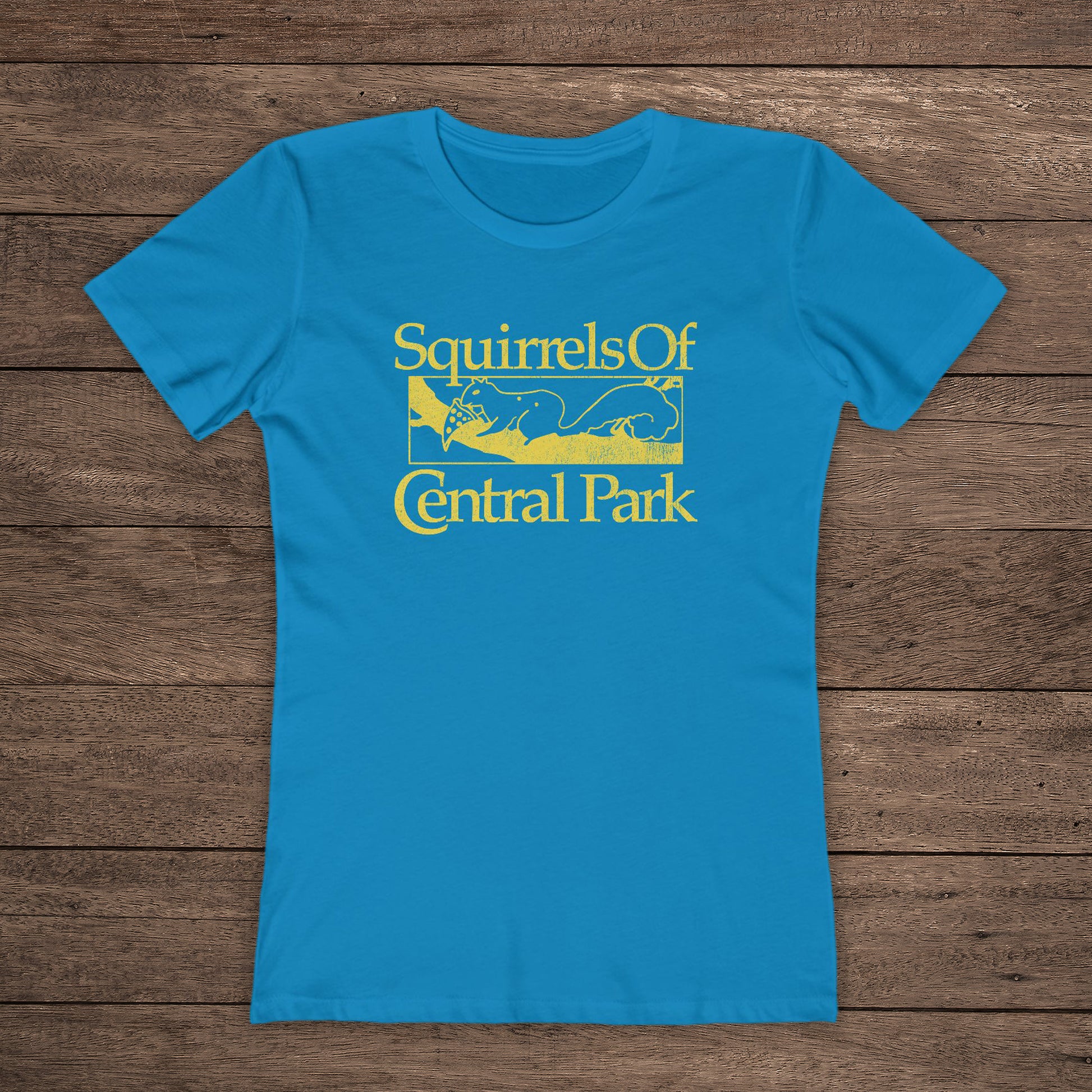 Front view of Turquoise women’s t-shirt with distressed yellow “Squirrels of Central Park” logo inspired by Bad Sisters.