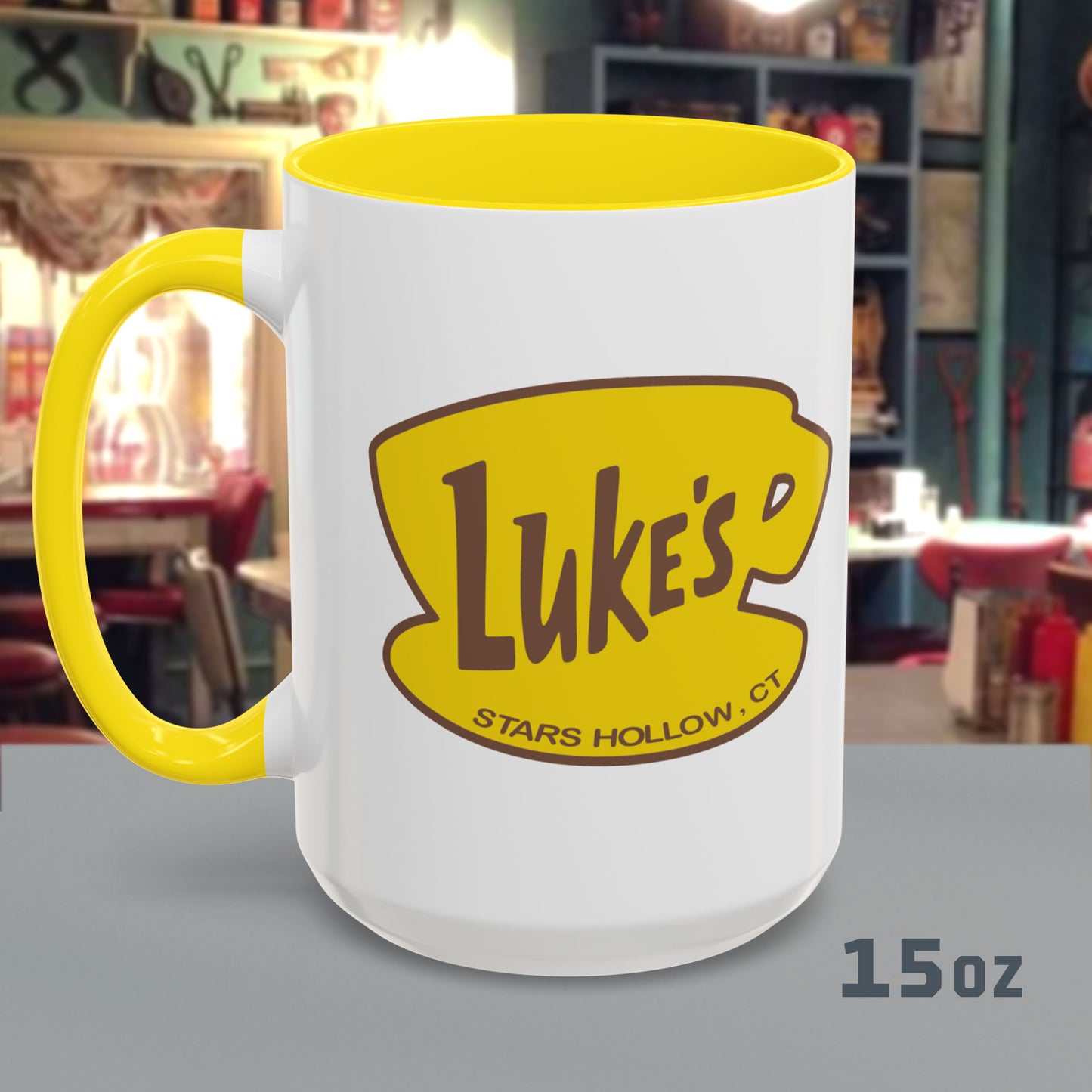 Front view of 15 oz White ceramic mug with yellow handle and Luke’s Diner logo from Gilmore Girls printed on both sides.