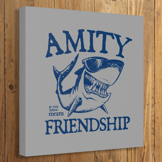 Funny Amity Island shark wall art canvas print inspired by Jaws with “Amity Means Friendship” and shark in sunglasses on a wooden wall.