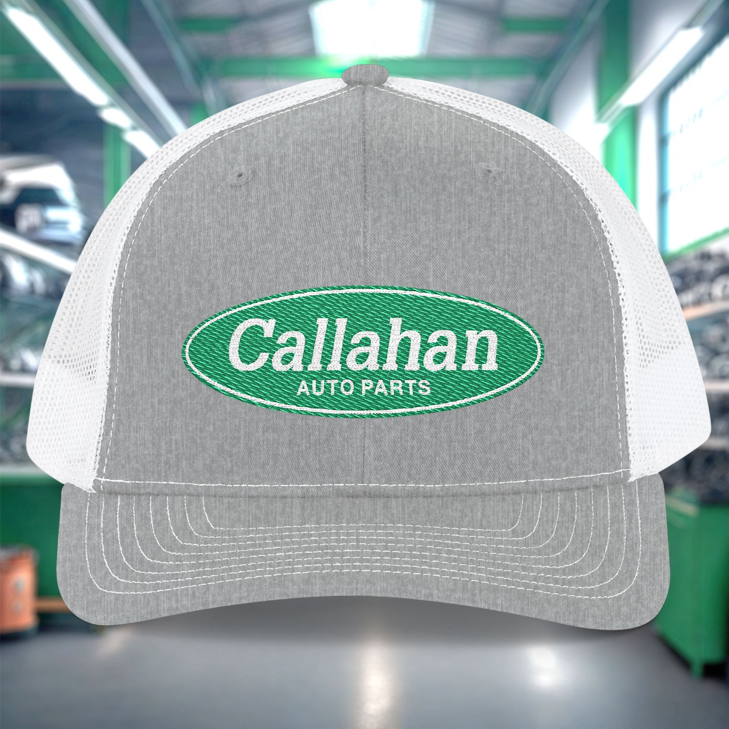 Gray and white cap with Callahan Auto Parts logo in a warehouse setting