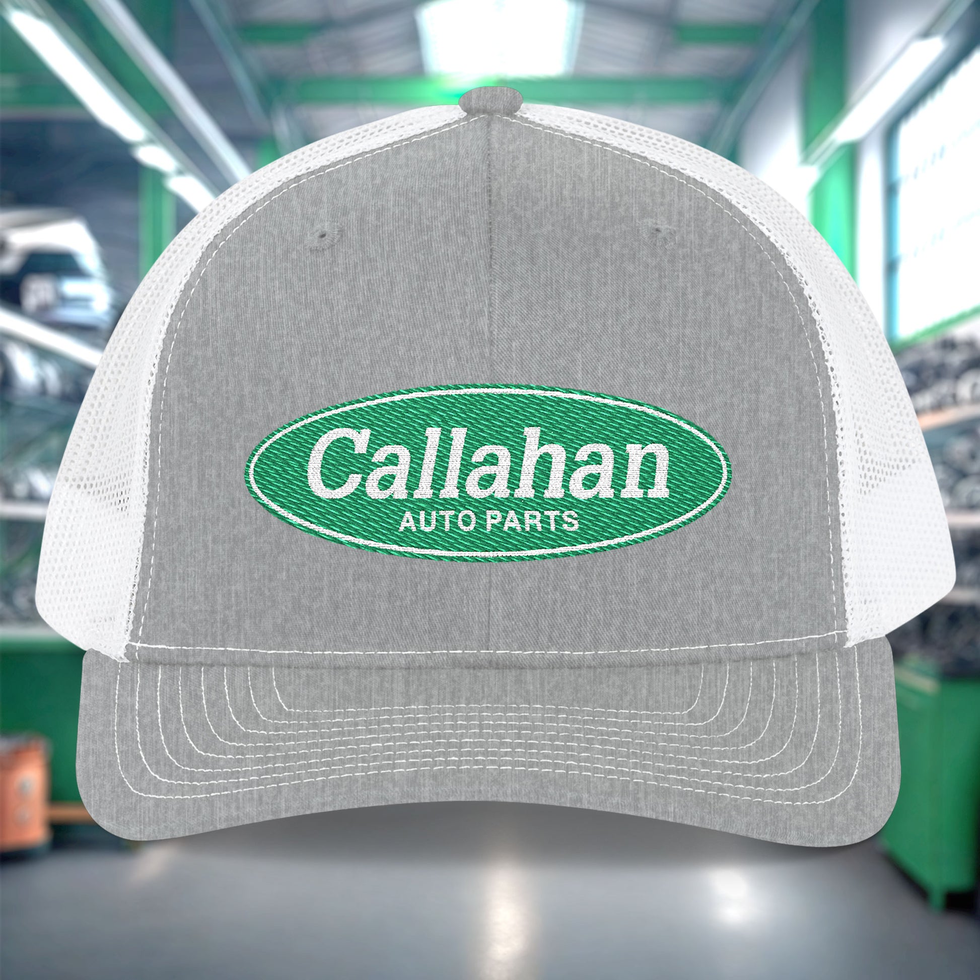 Gray and white cap with Callahan Auto Parts logo in a warehouse setting