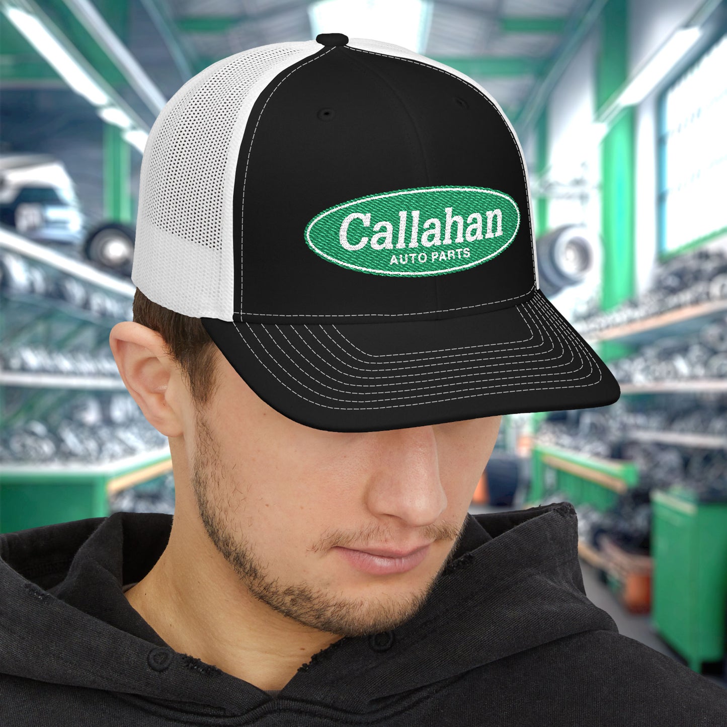 Man wearing Black and White Richardson 112 trucker cap with embroidered green Callahan Auto Parts logo inspired by Tommy Boy.