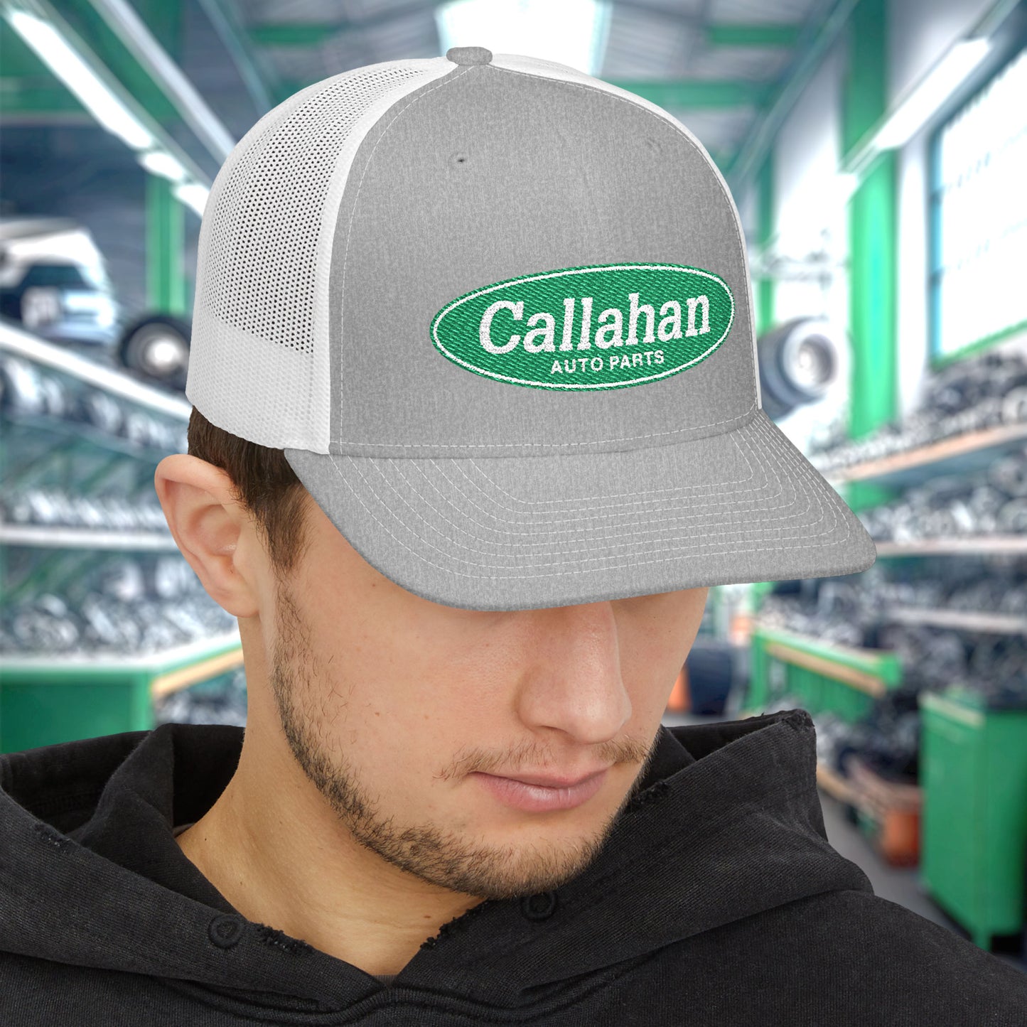 Man wearing Heather Gray and white Richardson 112 trucker cap with embroidered green Callahan Auto Parts logo inspired by Tommy Boy.