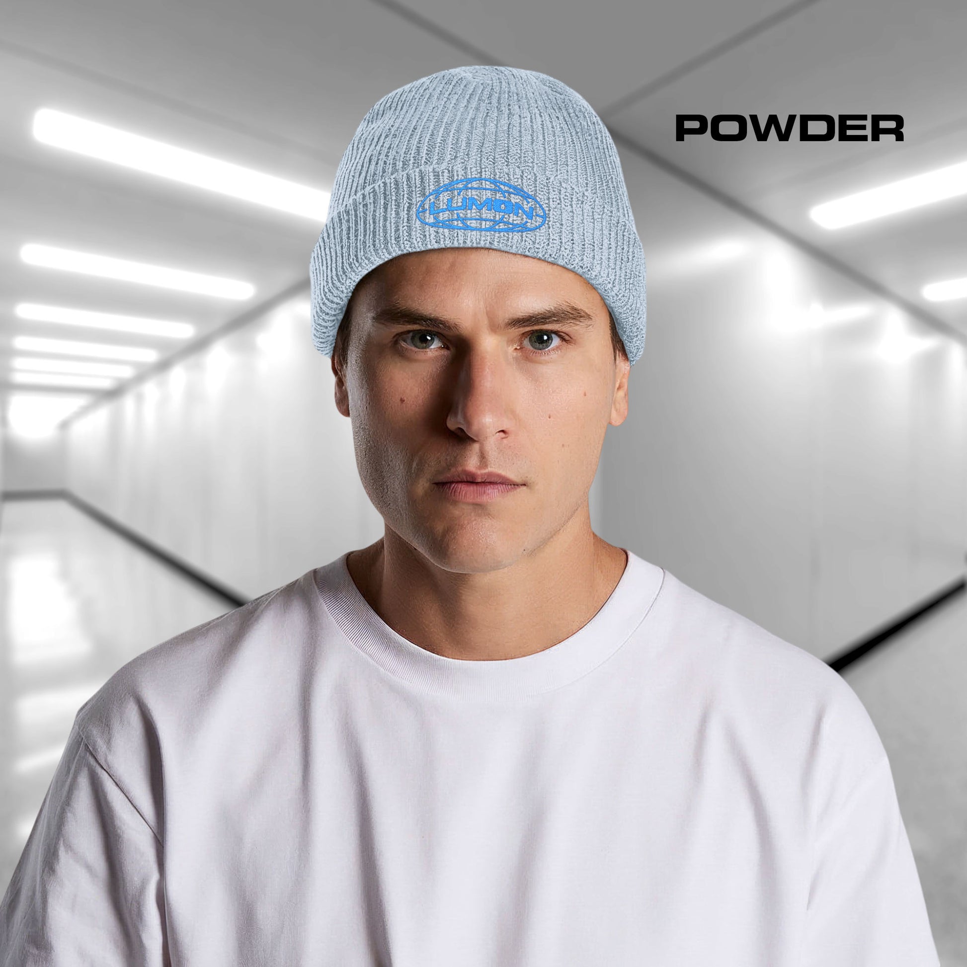 Man wearing a powder blue AS Colour cuff beanie with embroidered blue Lumon Industries logo from Severance, fisherman-style ribbed knit hat.